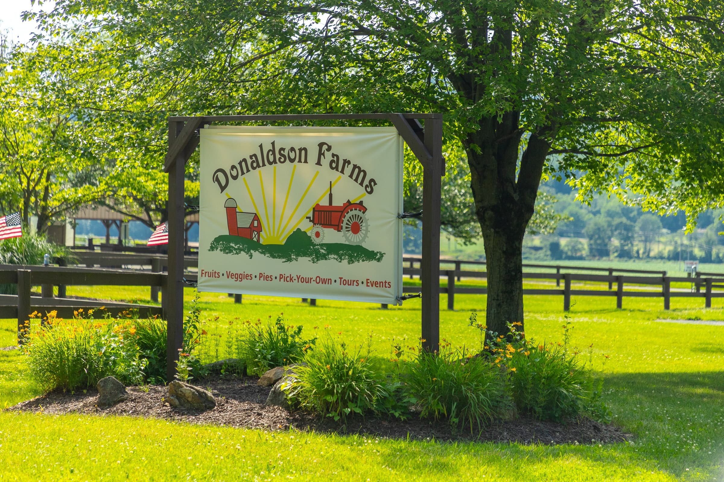 A sign for Donaldson Farms with a picture of a tractor and a sun.