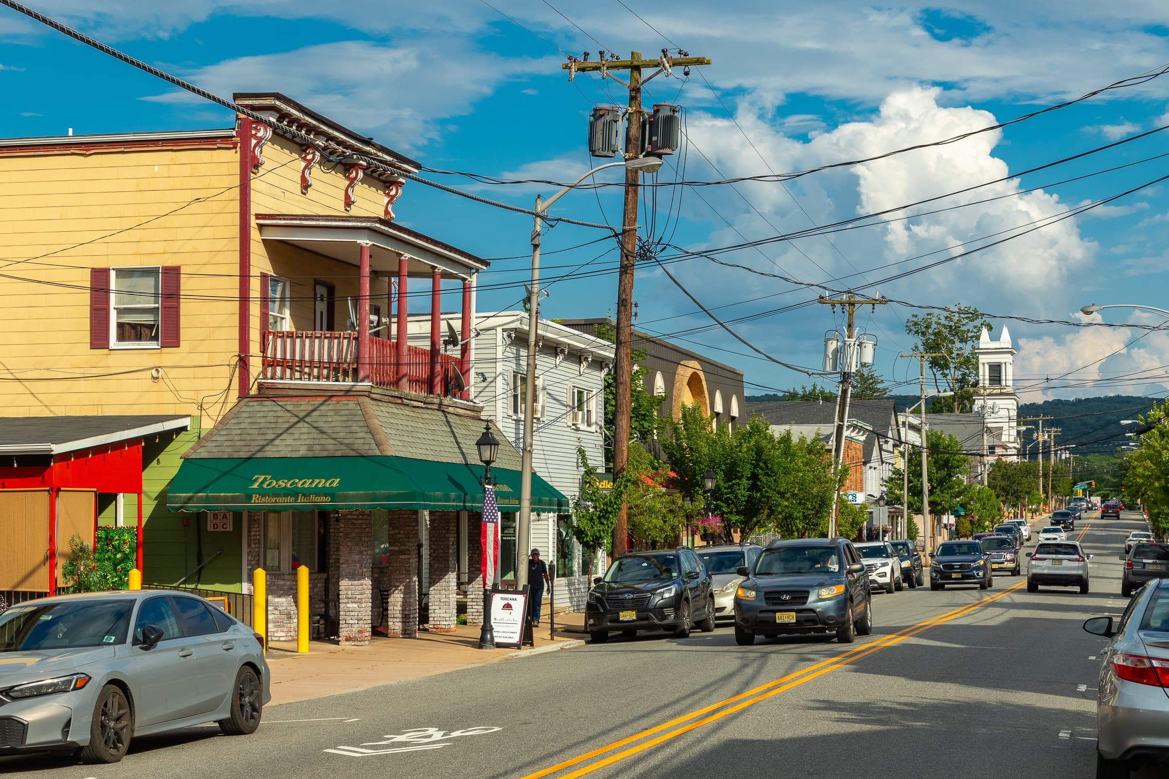 A street view with cars and buildings on a sunny day.