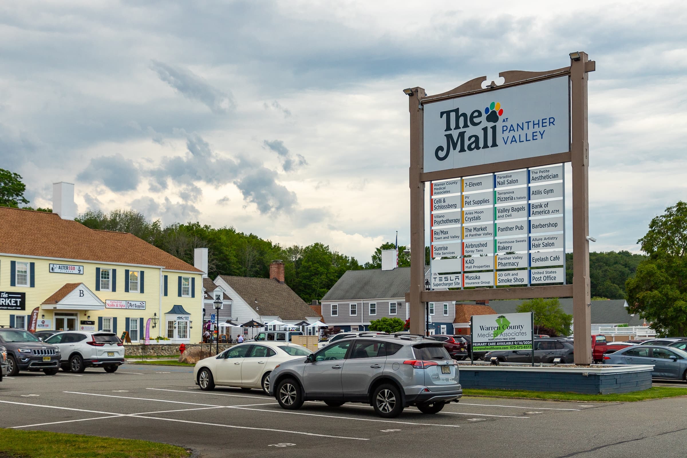 A sign for The Panther Mall Valley stands in front of a parking lot.