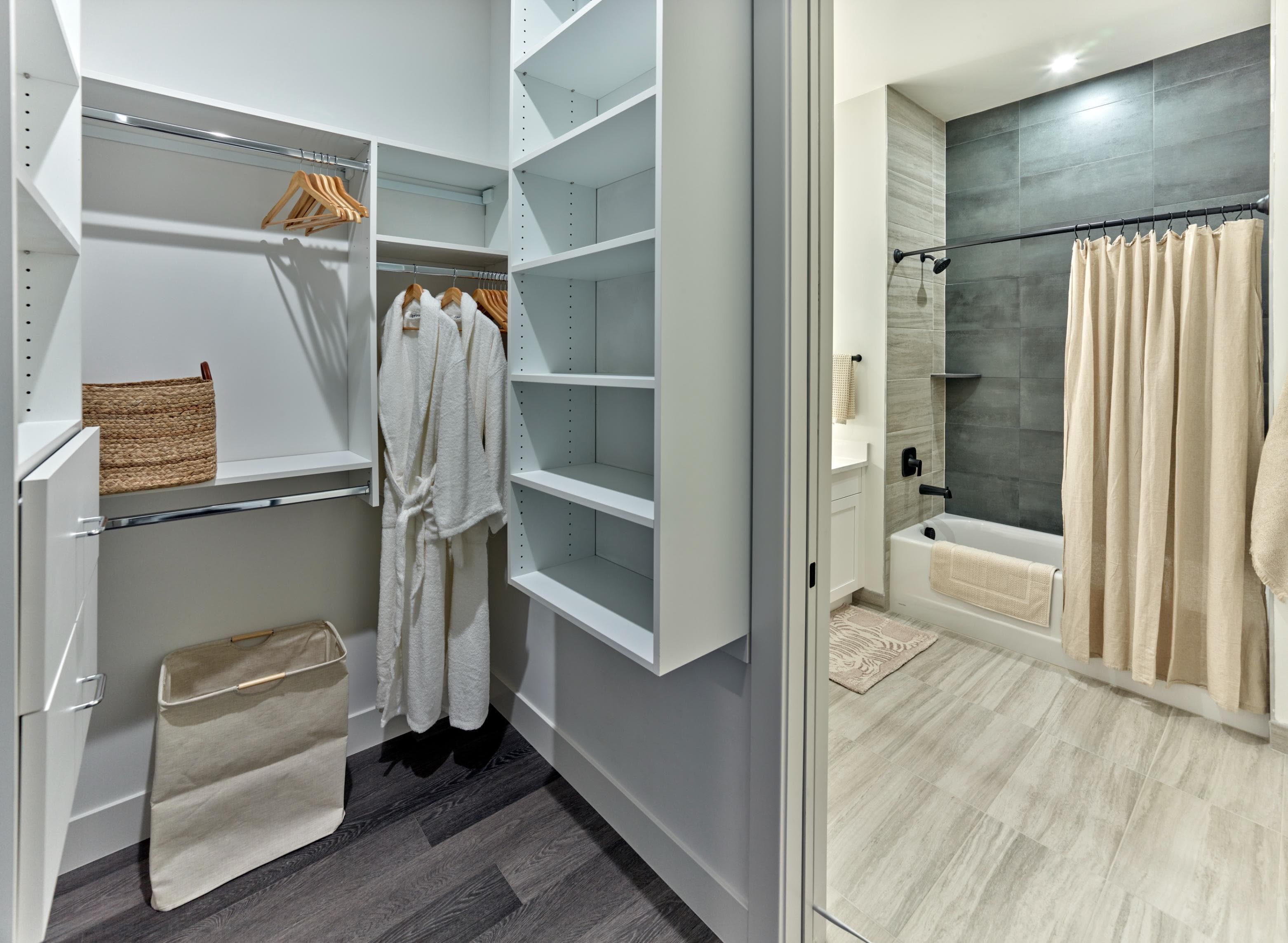 A bathroom with a walk-in shower and a large closet with white shelves.