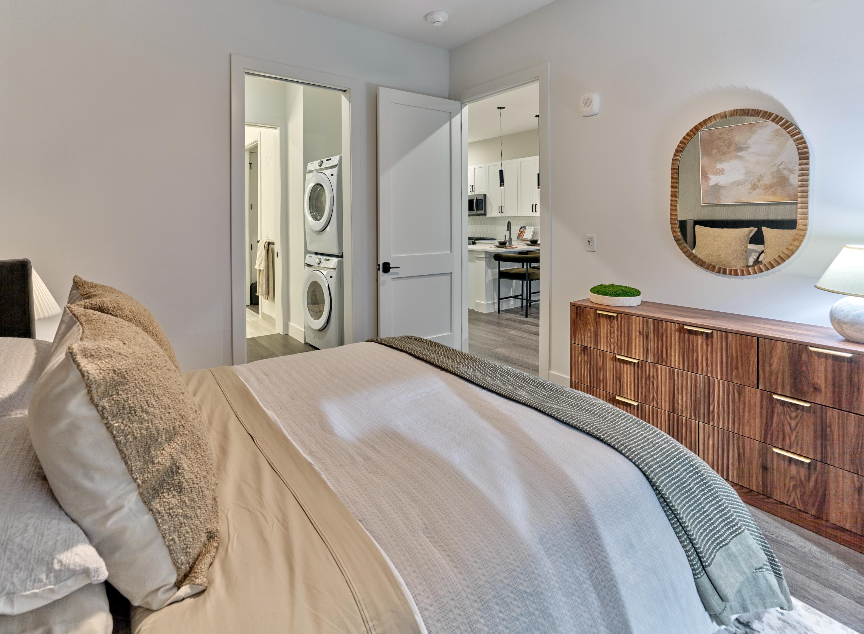 A bedroom with a large bed and a mirror on the wall.