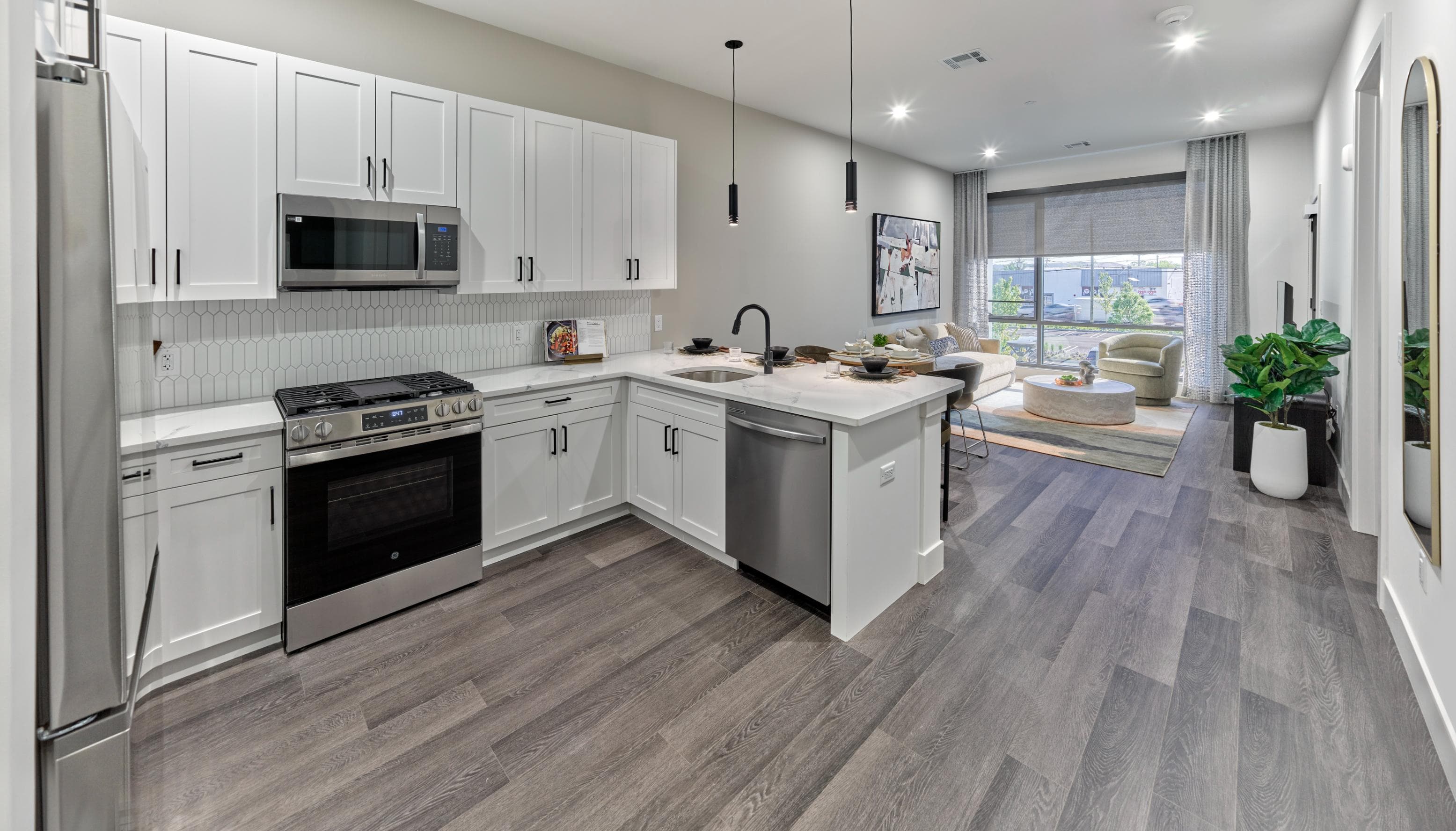 A modern kitchen with white cabinets and stainless steel appliances.