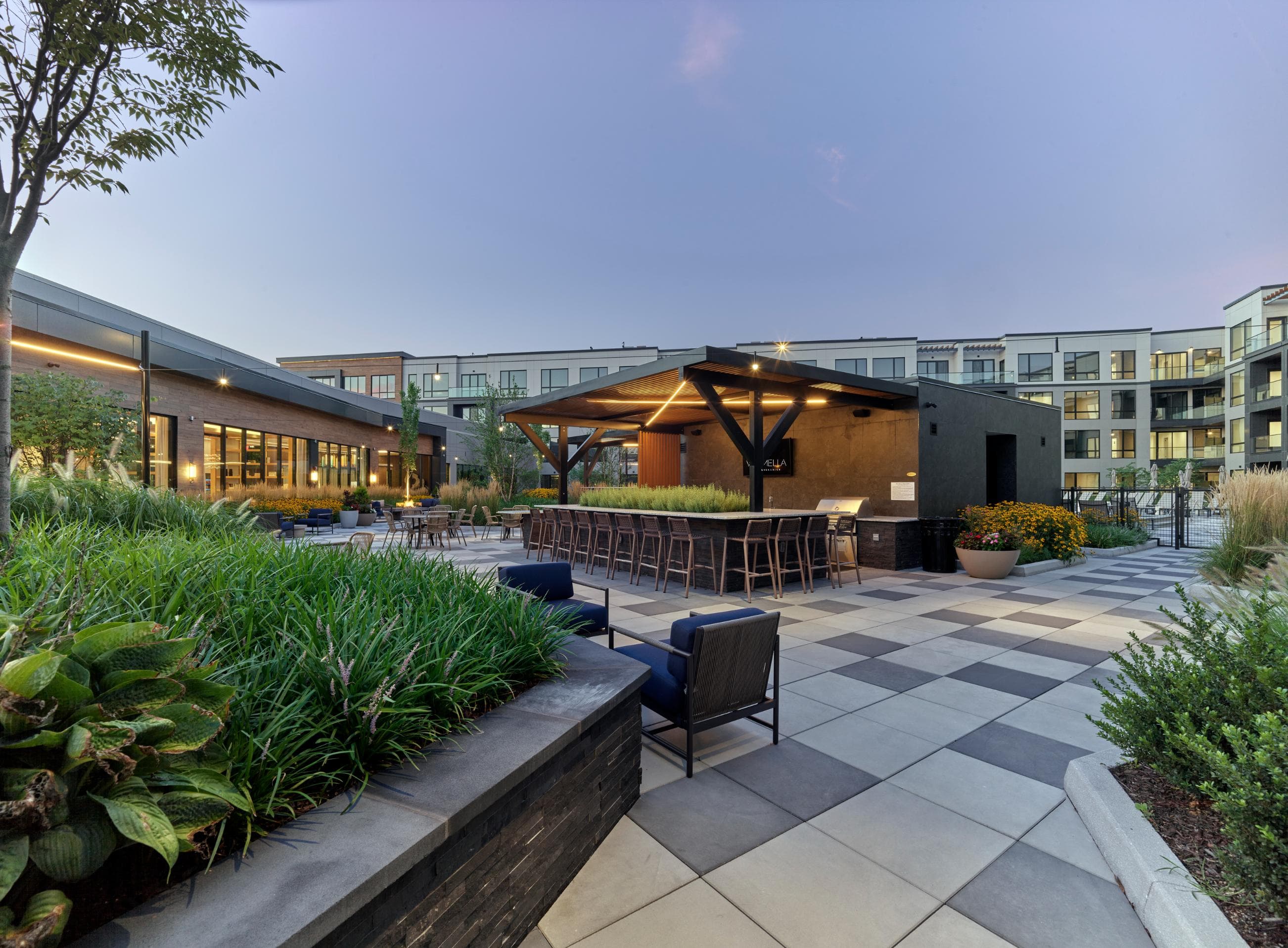 A modern outdoor seating area with a mix of furniture and greenery.