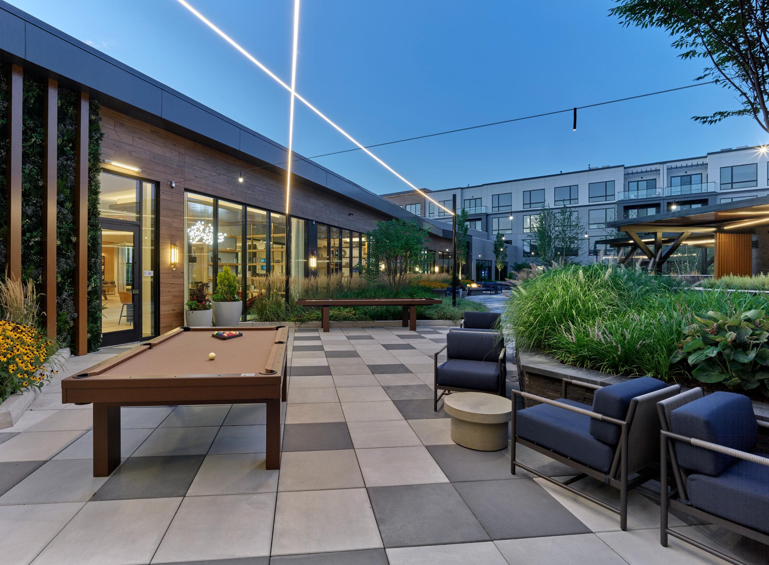 A pool table is surrounded by chairs in a patio area.