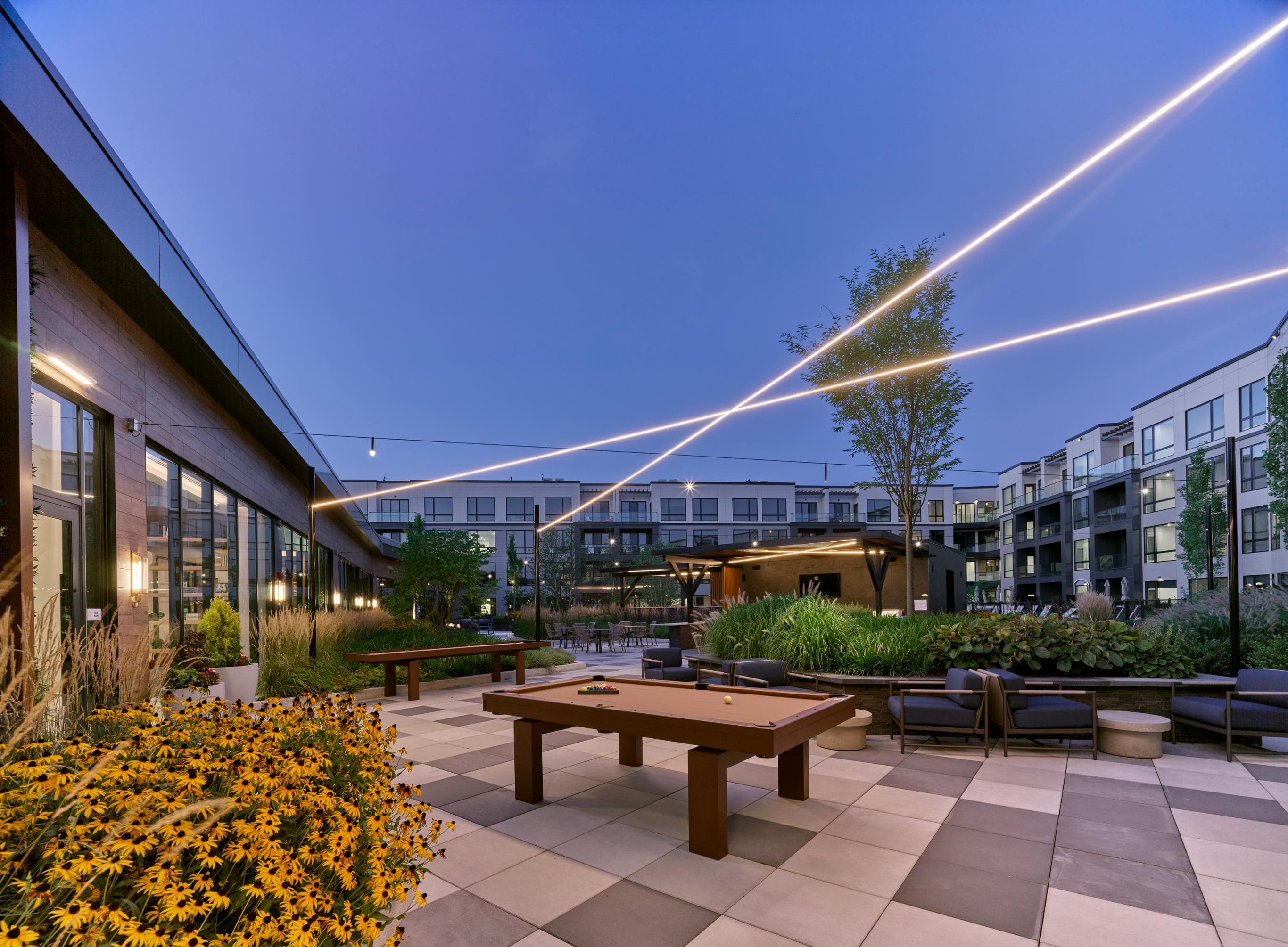 A sunset view of a patio with a table and chairs.