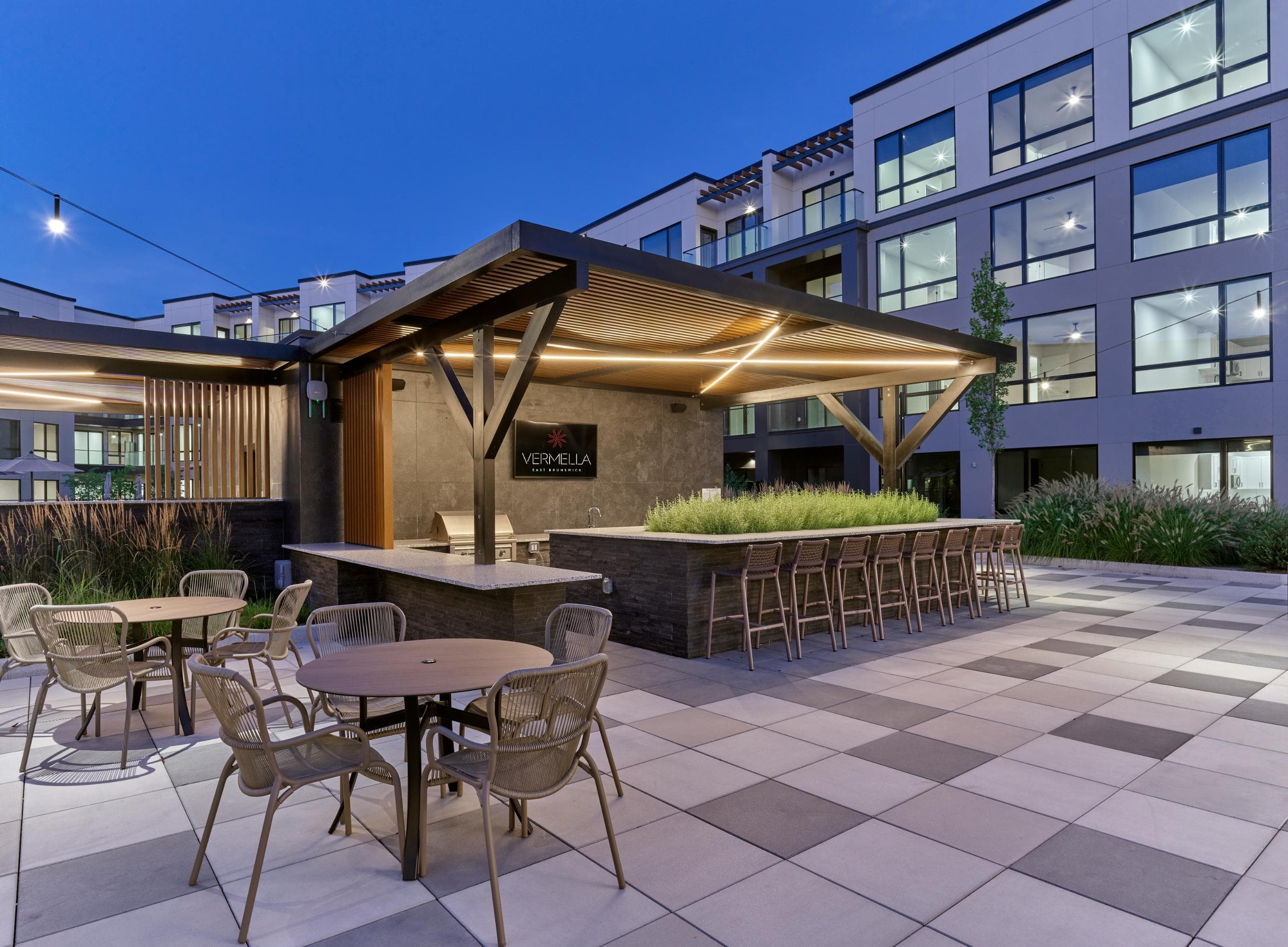 A patio with a bar and chairs is set up outside a building.