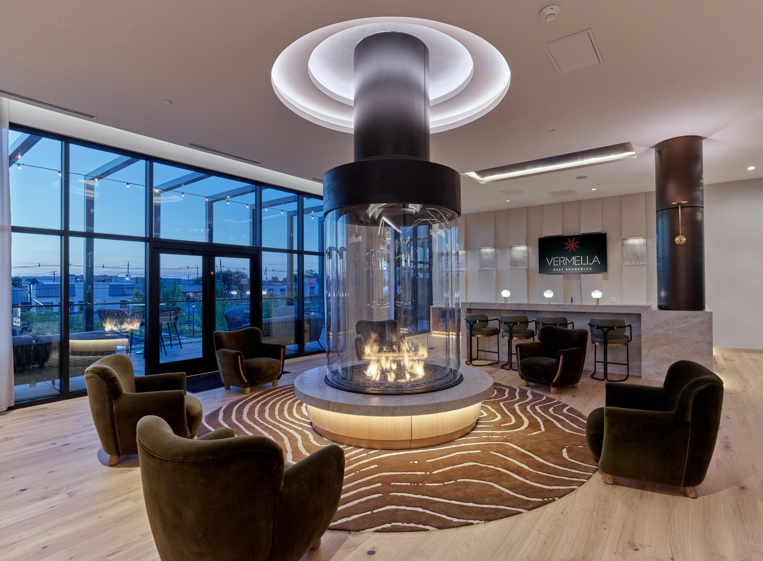 A modern living room with a fireplace and a view of the city.