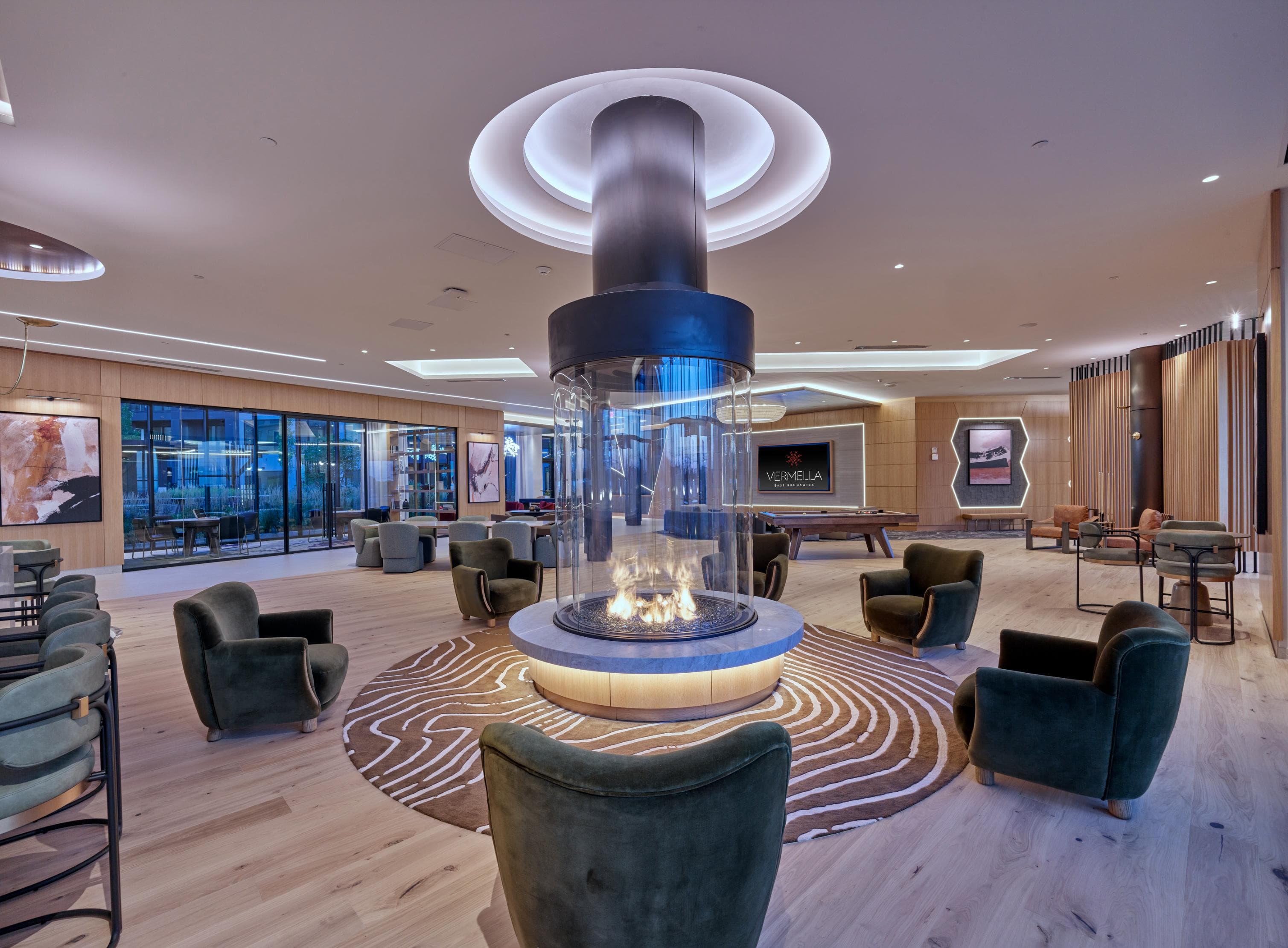 A modern living room with a central fireplace and a variety of seating options.