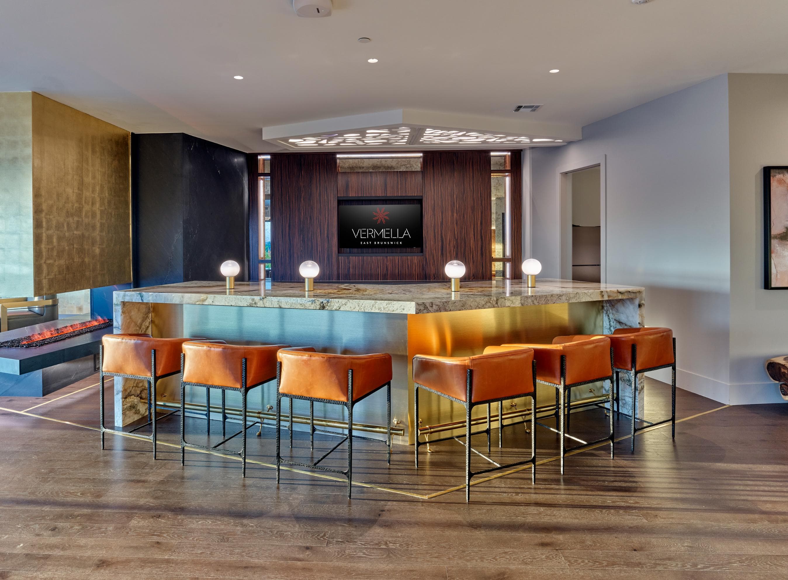 A bar with orange chairs and a counter with a sign that says