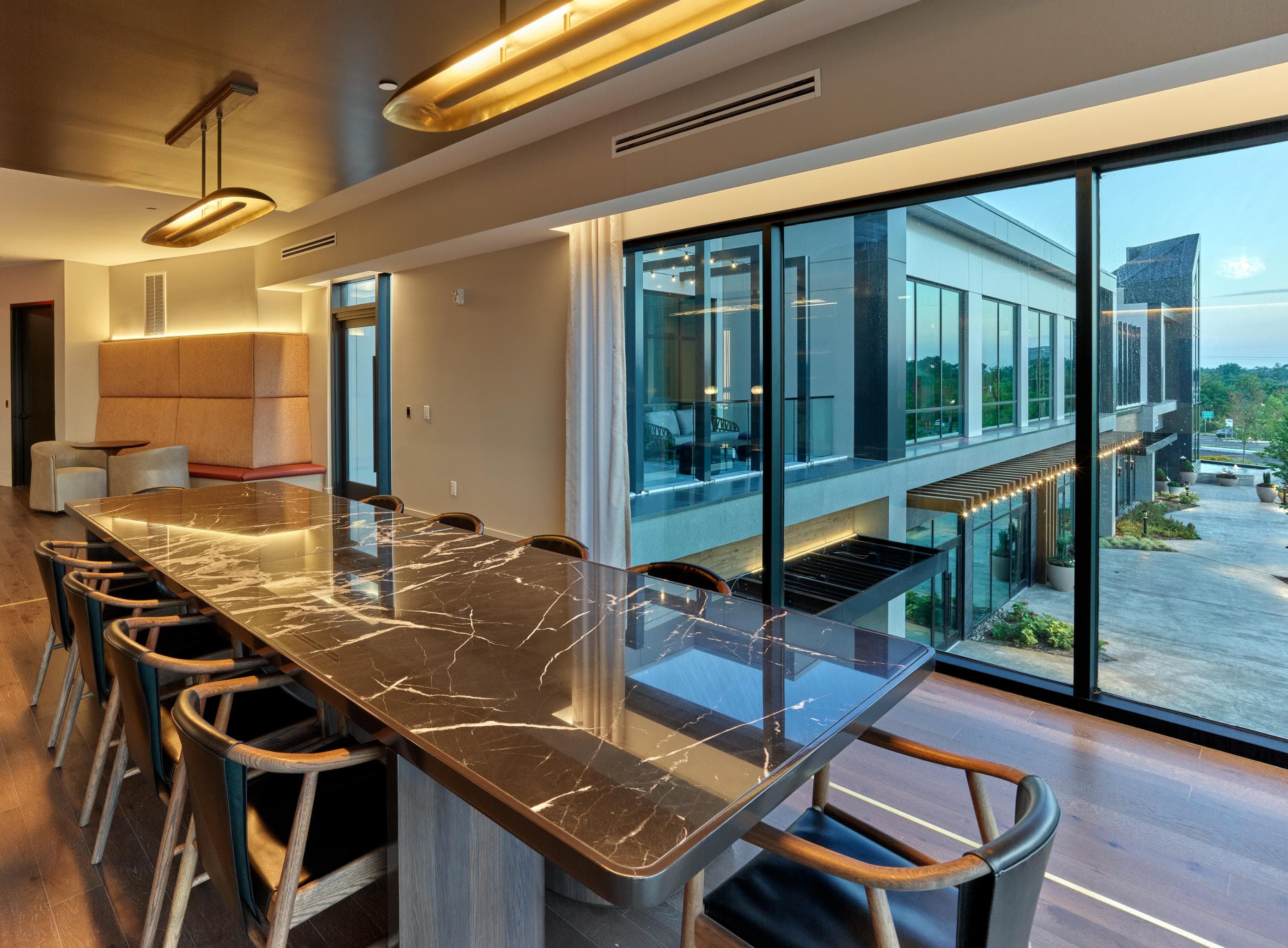 A modern kitchen with a long counter and chairs.
