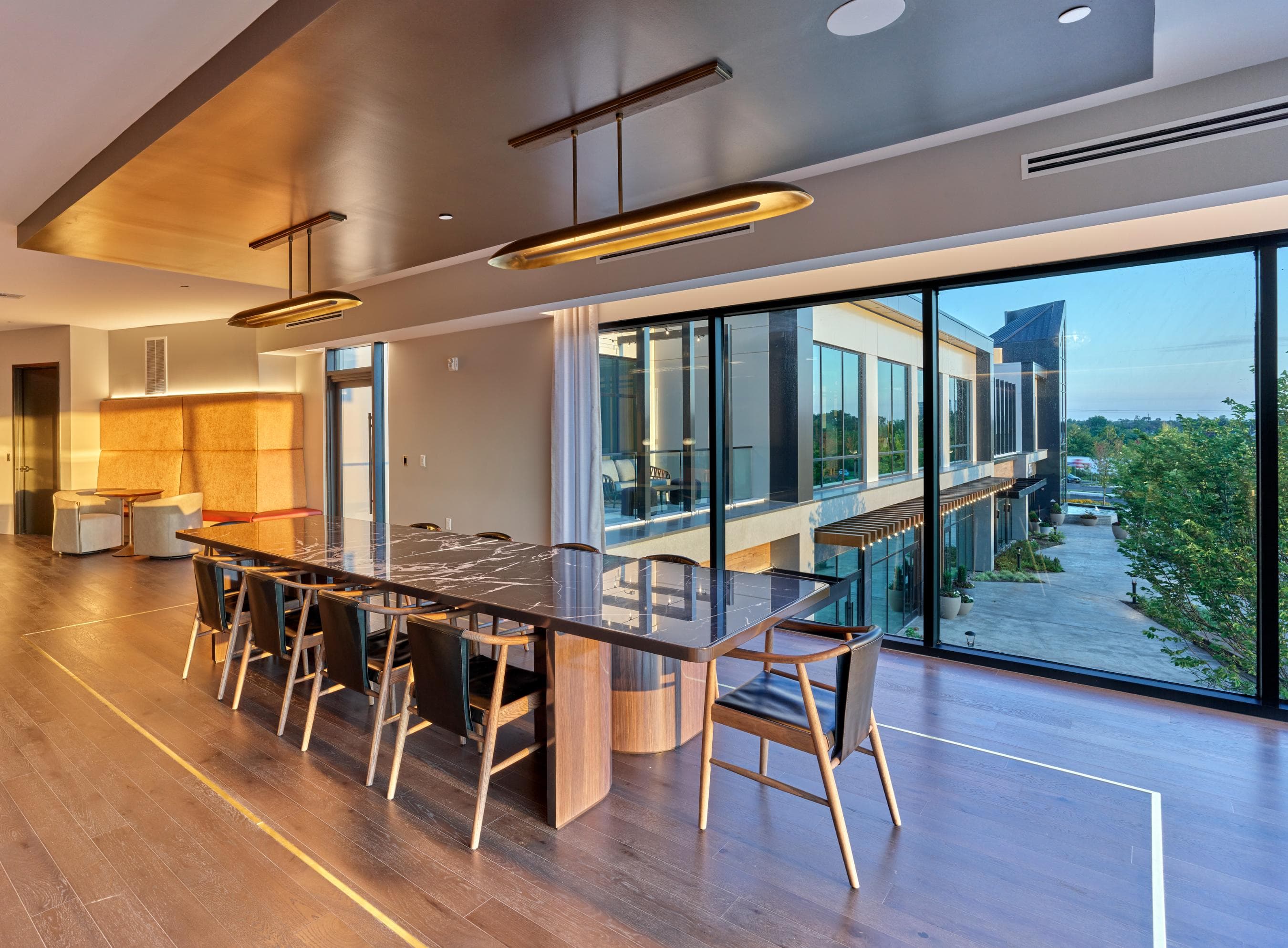 A modern dining room with a long table and chairs.