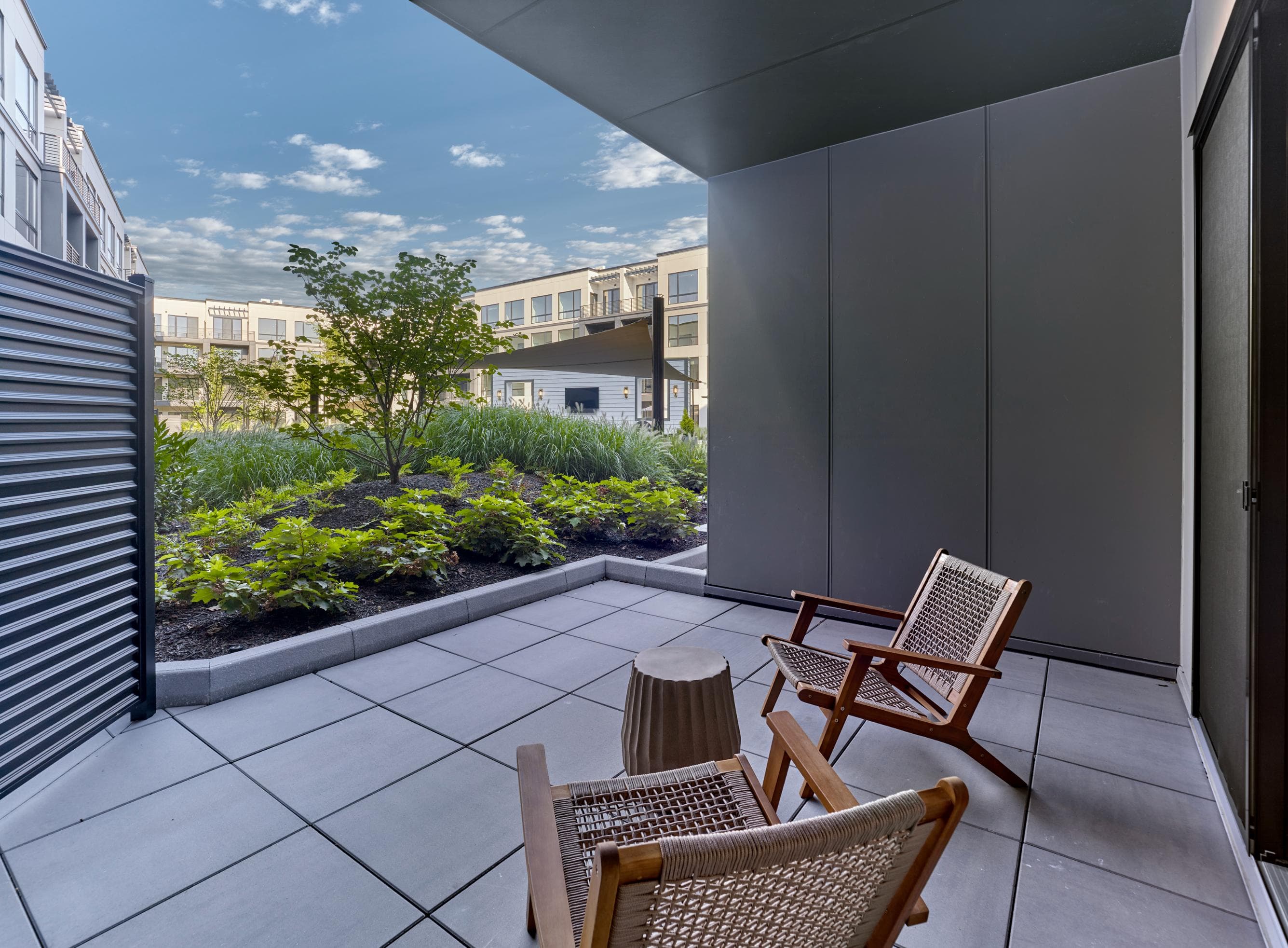 A patio with two chairs and a table with a view of the sky.
