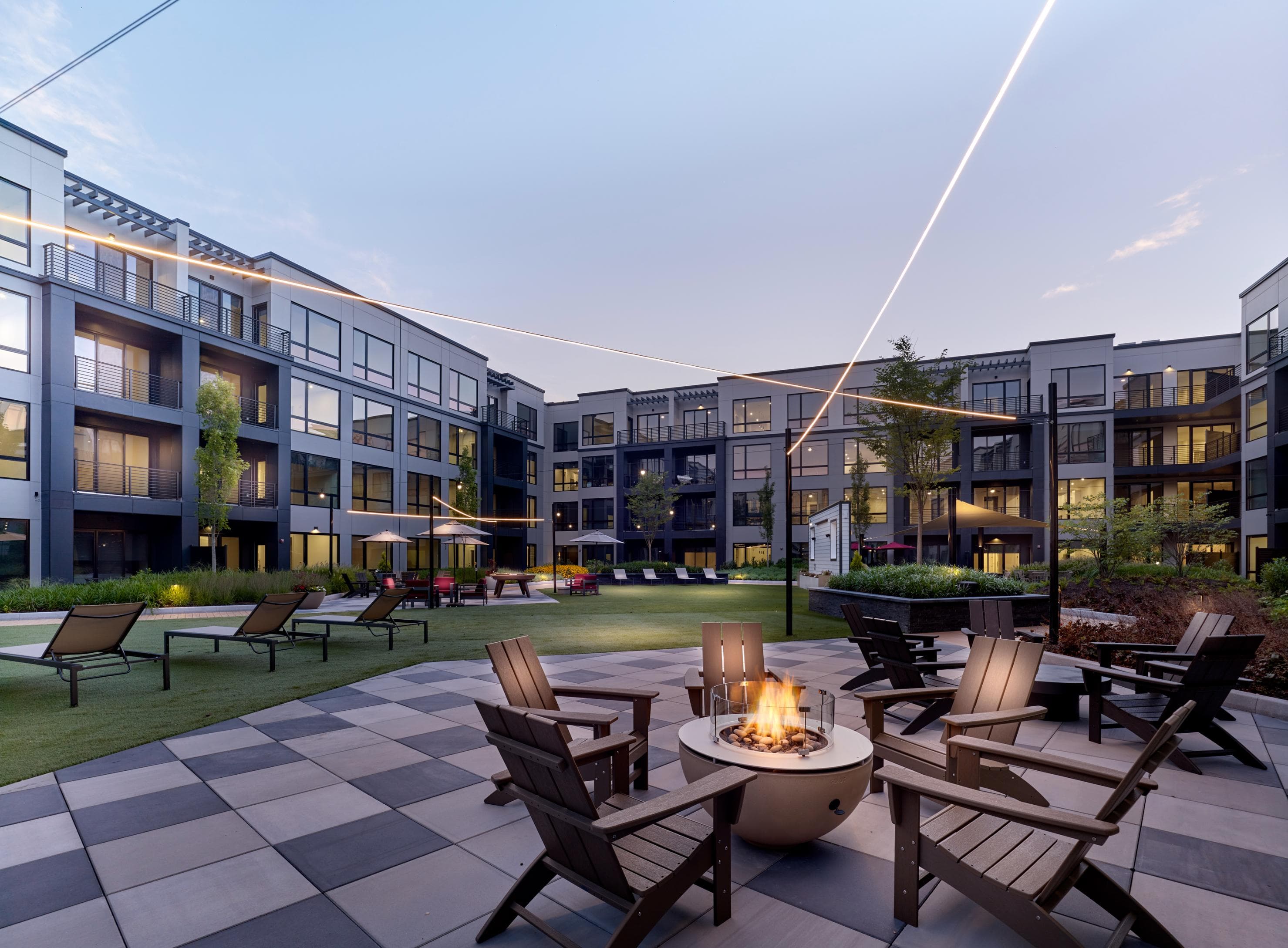 A modern building with a fire pit in the foreground.