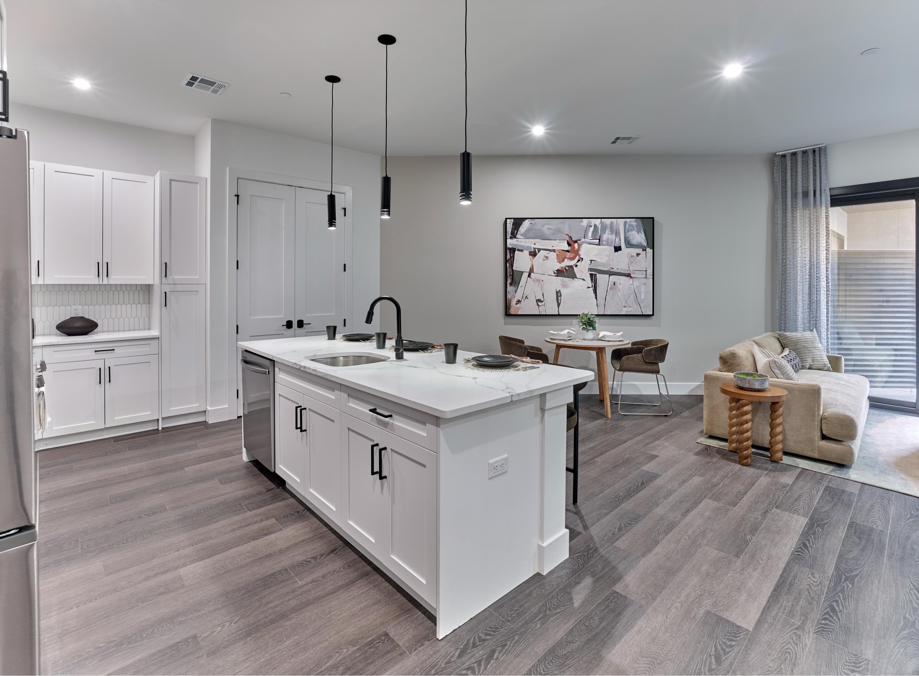 A modern kitchen with white cabinets and a large island.