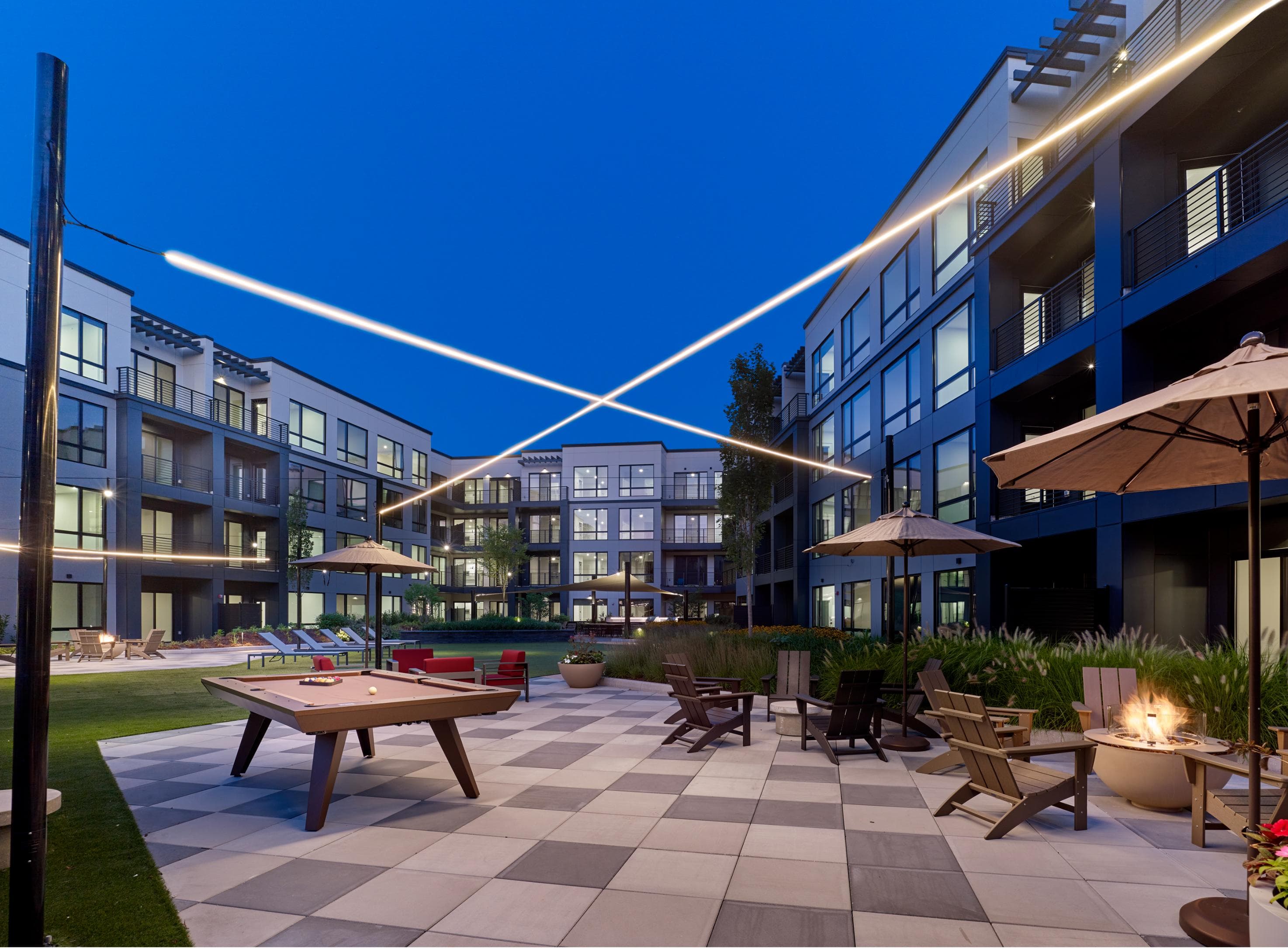 A modern outdoor seating area with a checkered floor and a fire pit.