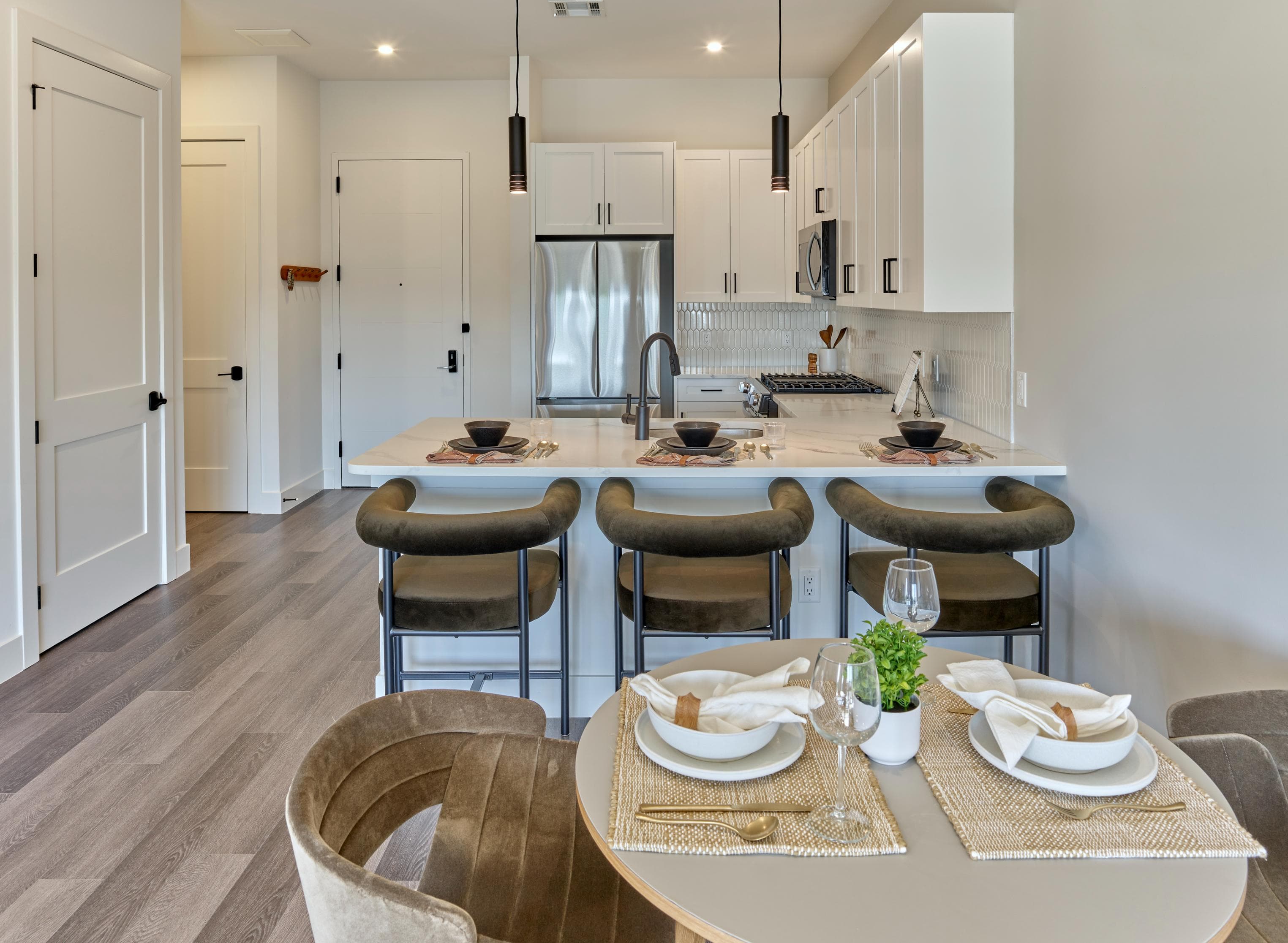 A modern kitchen with a dining table set for two.