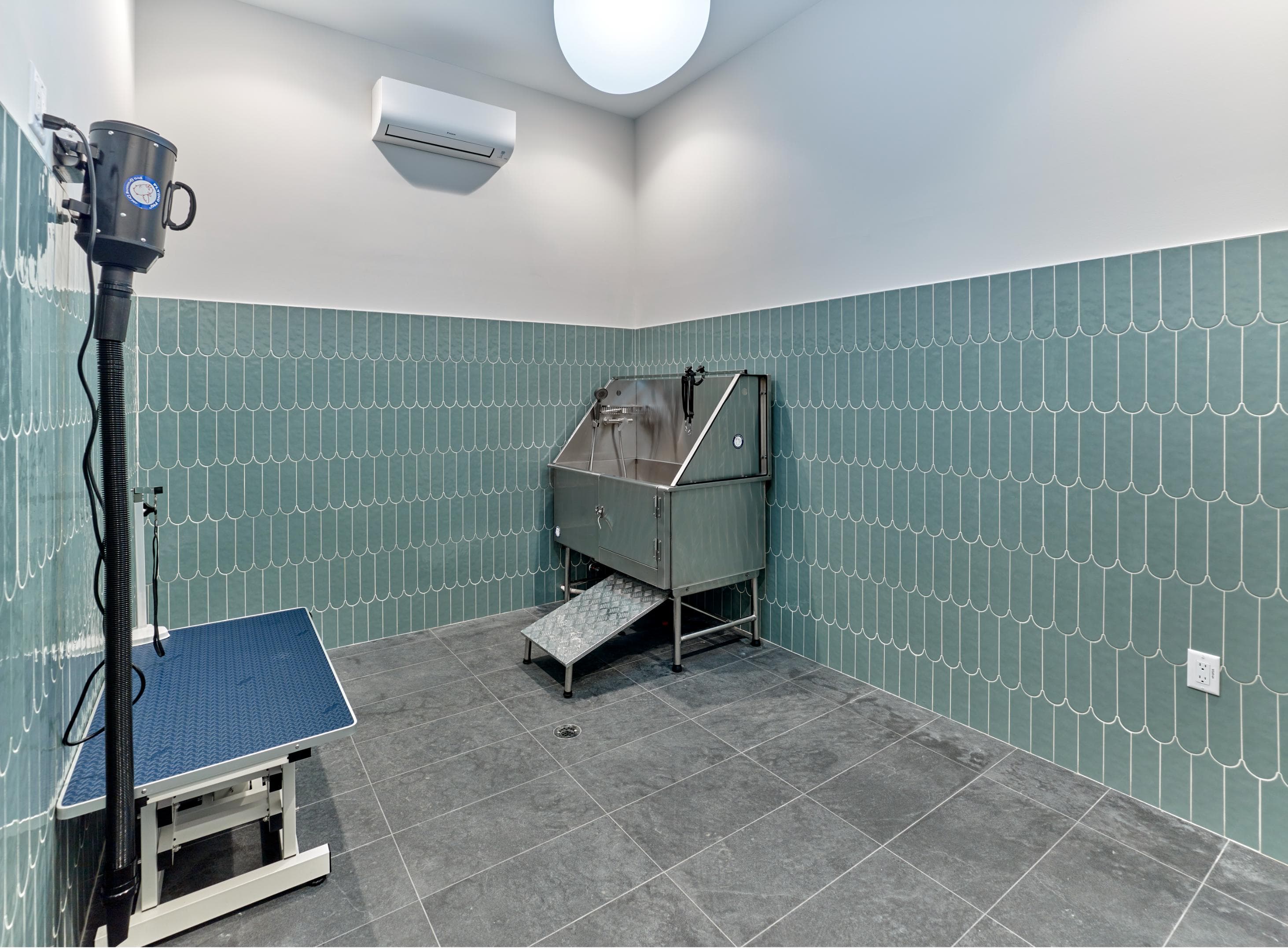 A room with a blue tile wall and a sink.