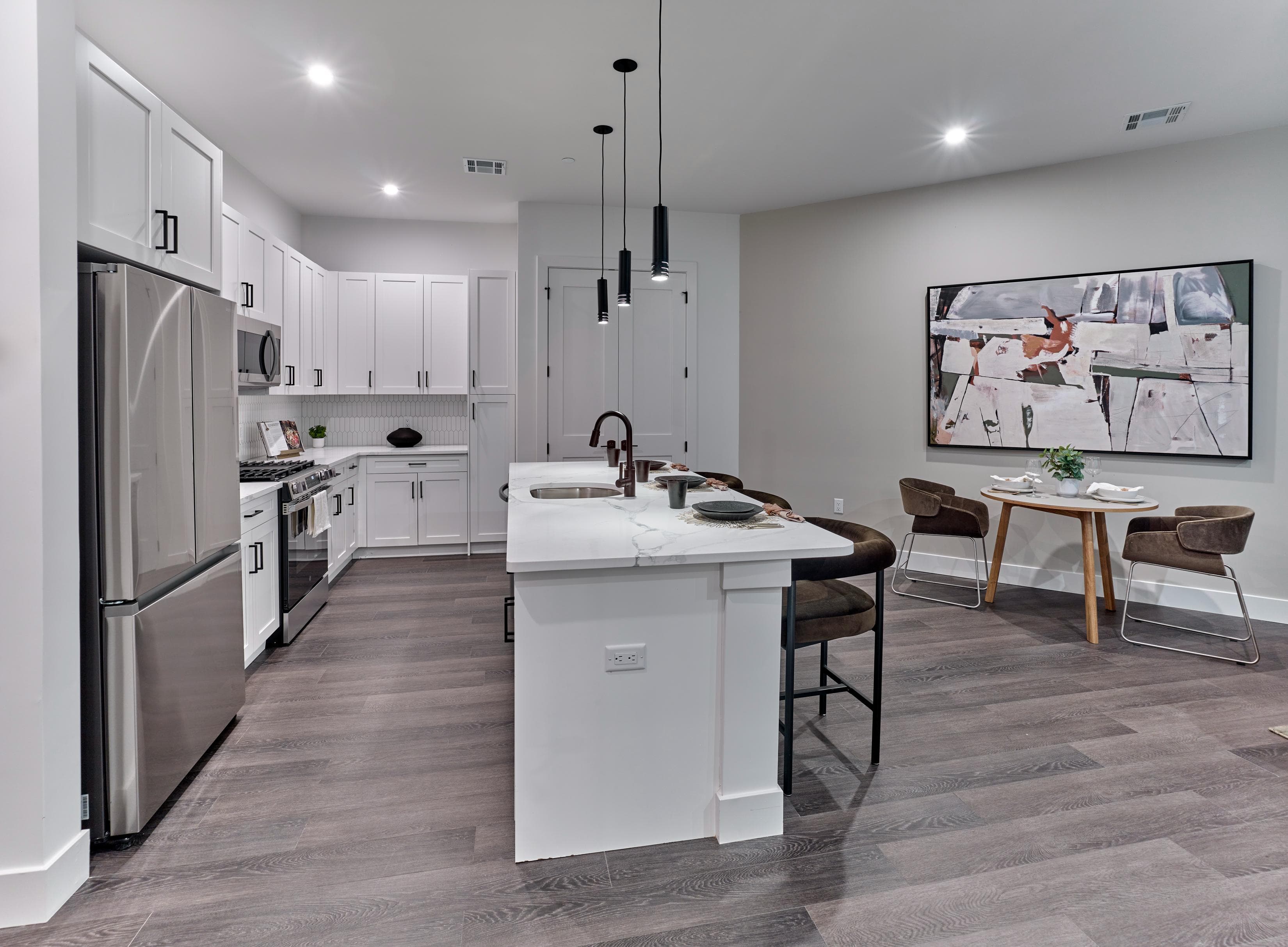 A modern kitchen with a white island and stainless steel appliances.