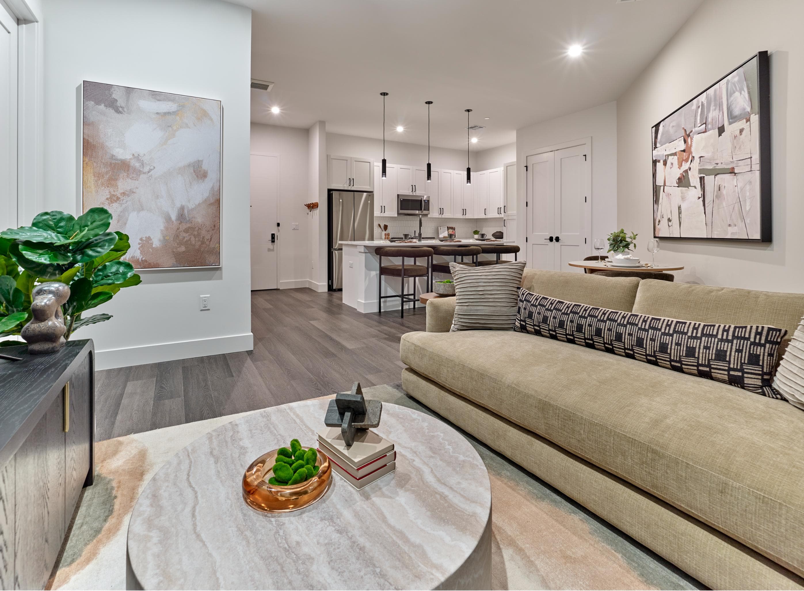 A modern living room with a couch, coffee table, and artwork on the walls.