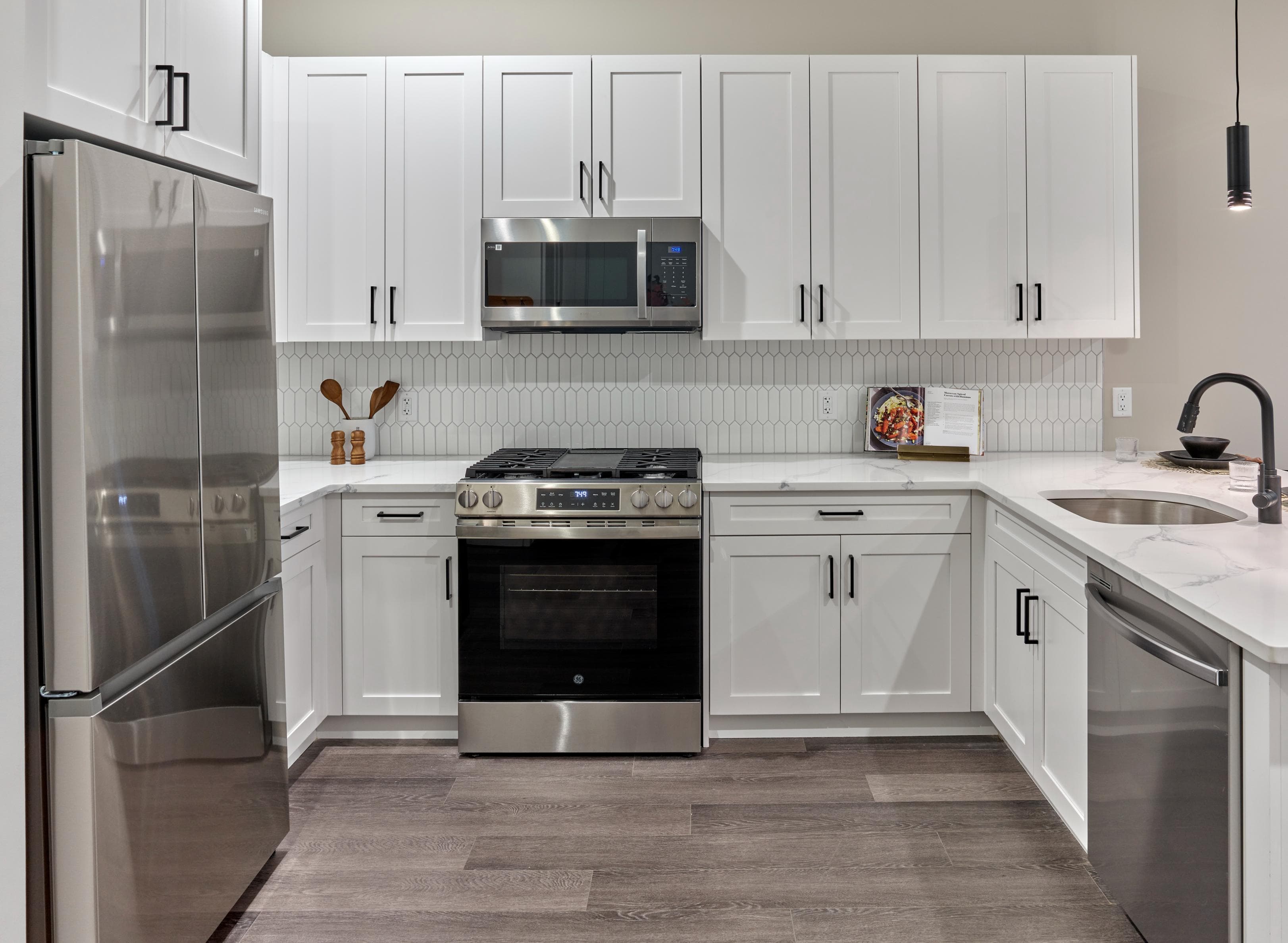 A modern kitchen with white cabinets and stainless steel appliances.