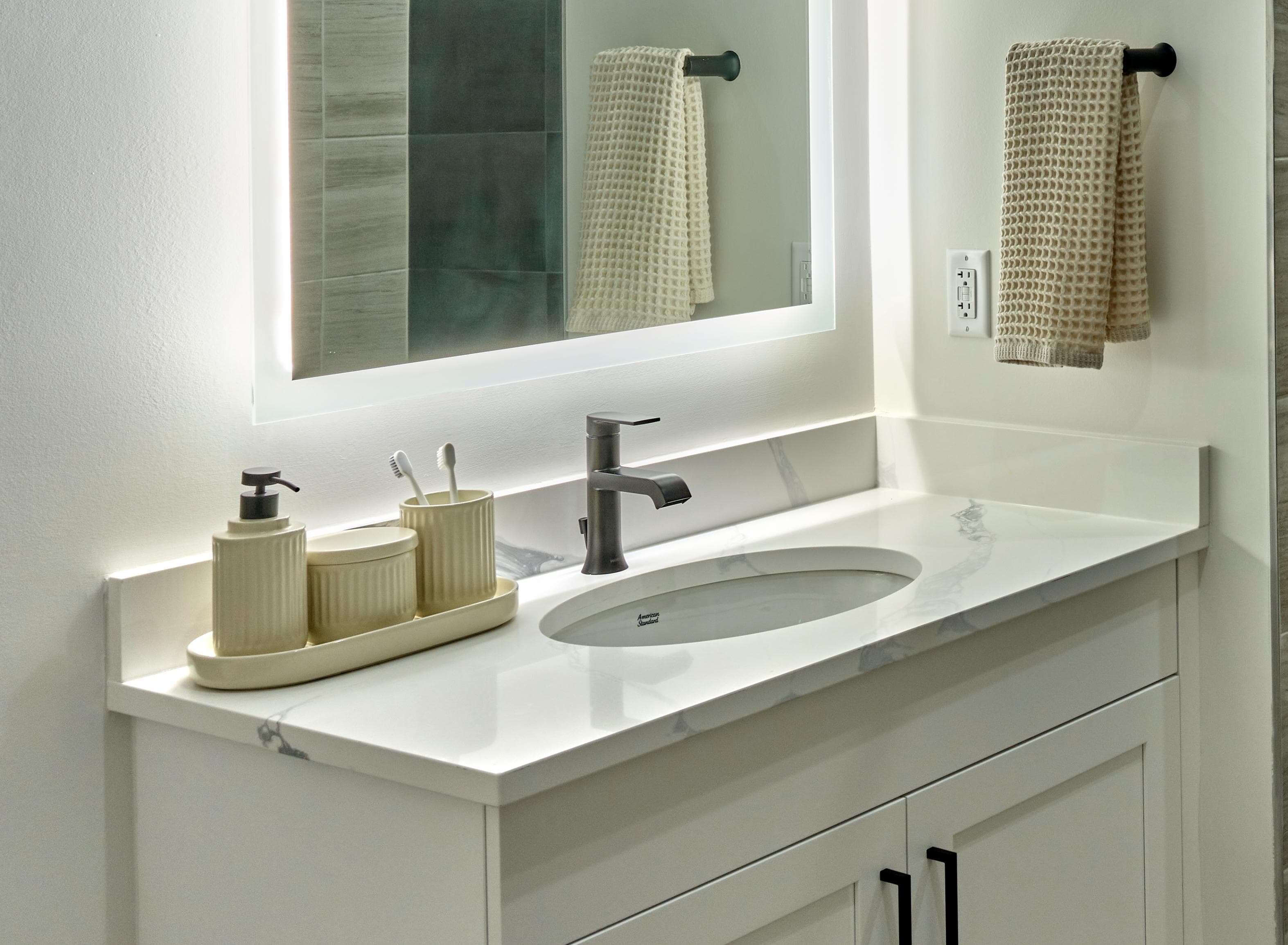 A white bathroom sink with a tray of toiletries on the counter.