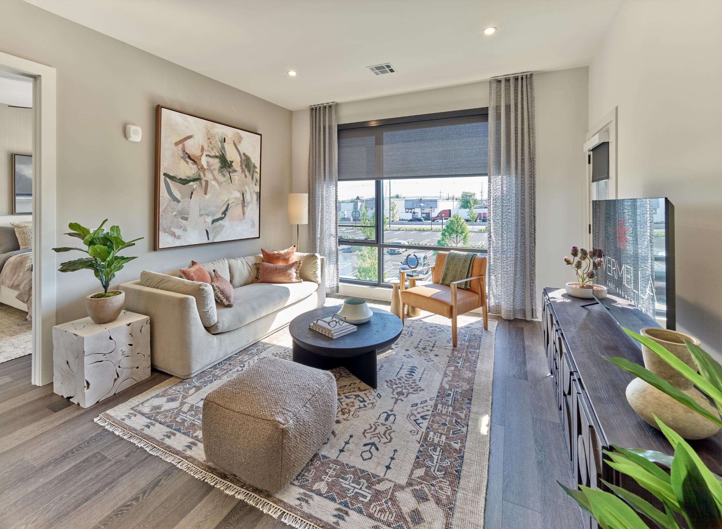 A living room with a couch, coffee table, and a painting on the wall.