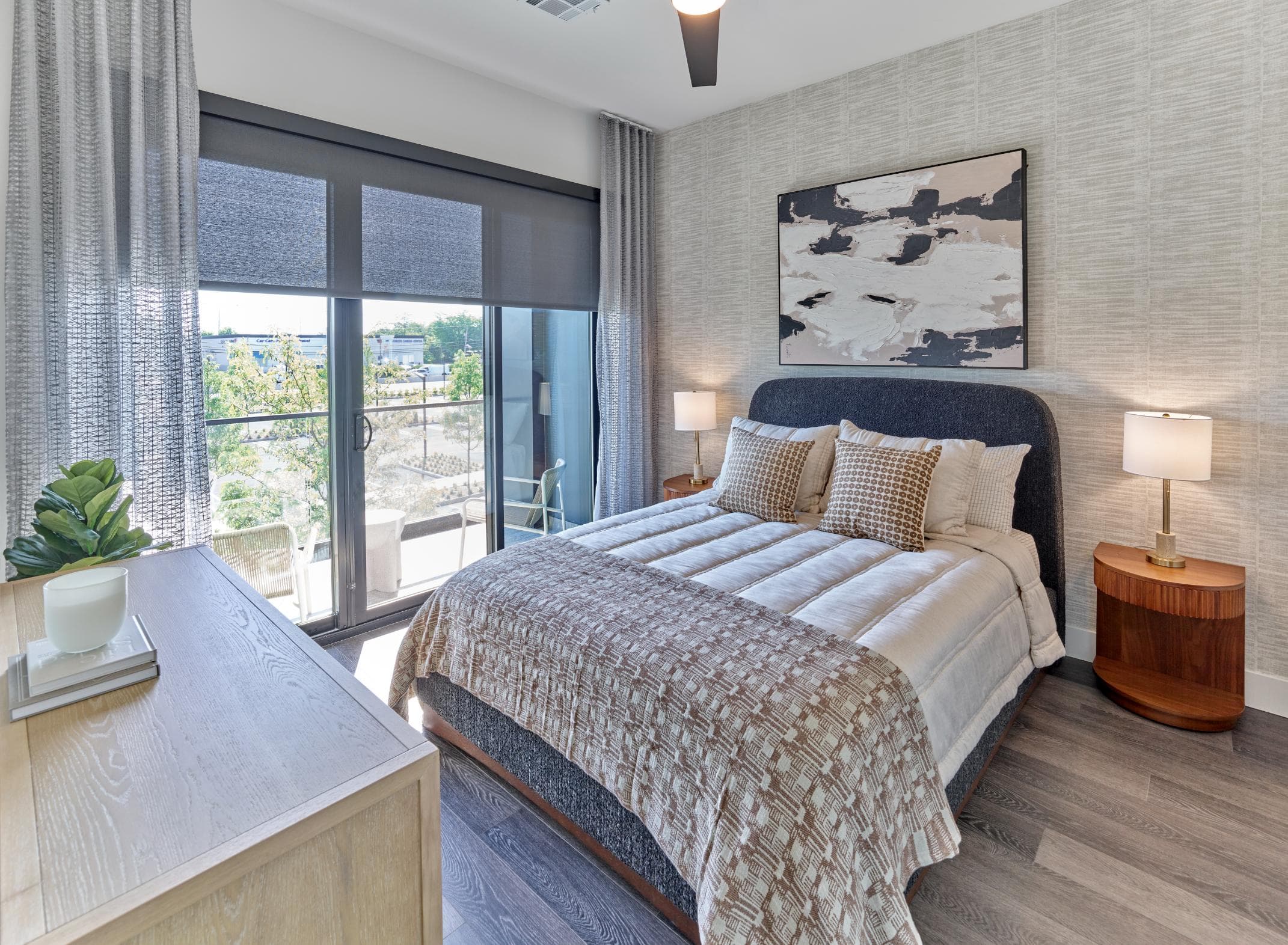 A bedroom with a large bed and a view of the outdoors through the window.