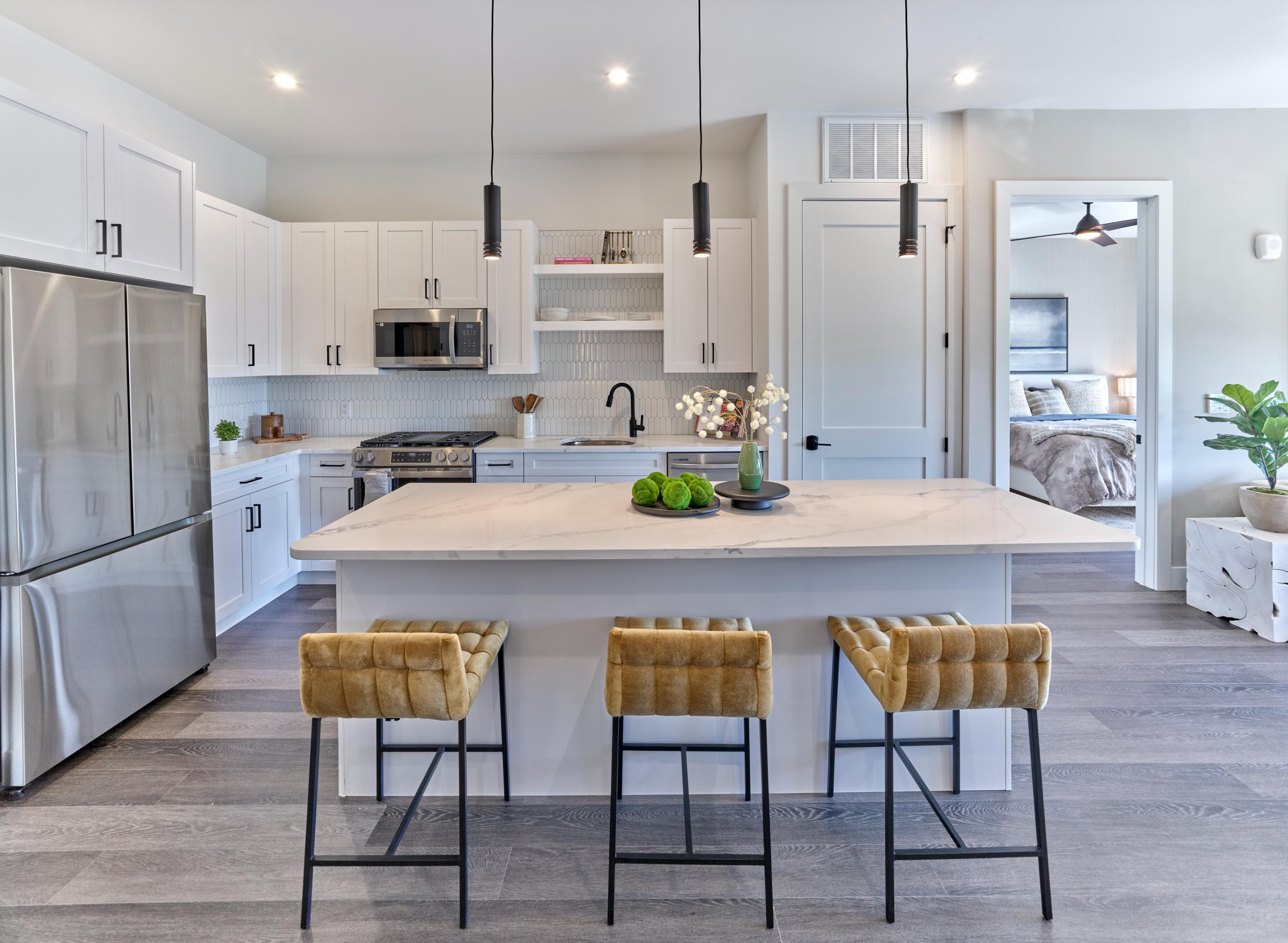 A modern kitchen with a large island and bar stools.