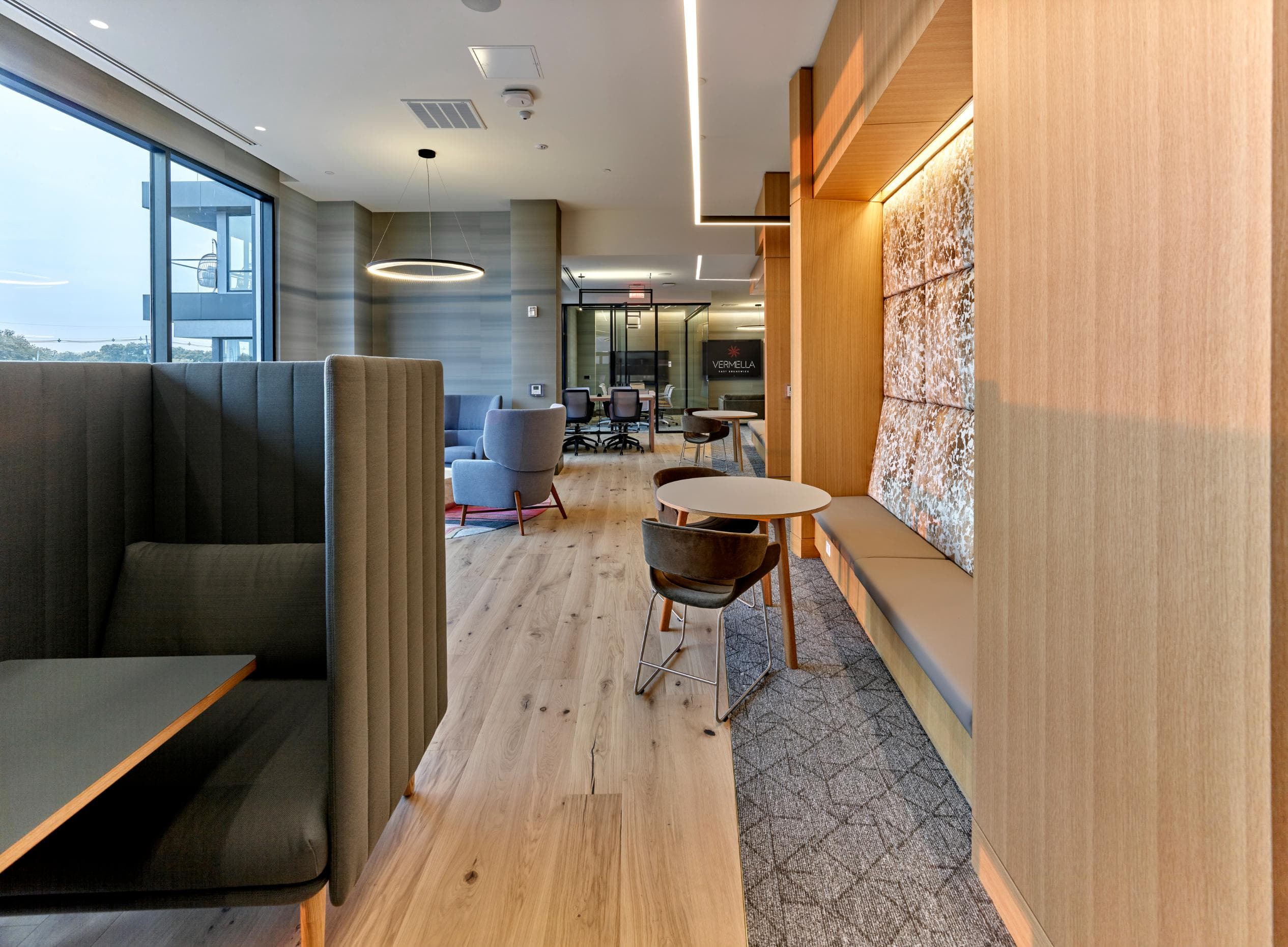 A modern office space with a long wooden table and chairs.