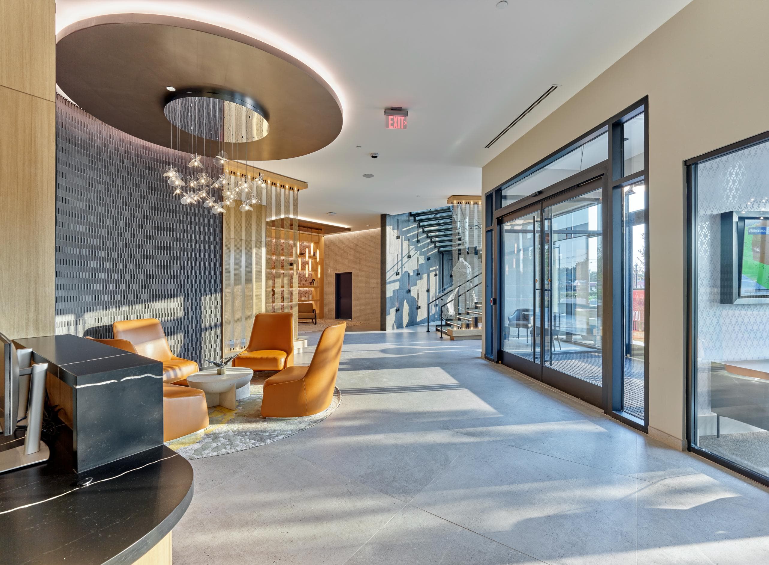A modern interior space with a curved ceiling, a staircase, and a reception desk.