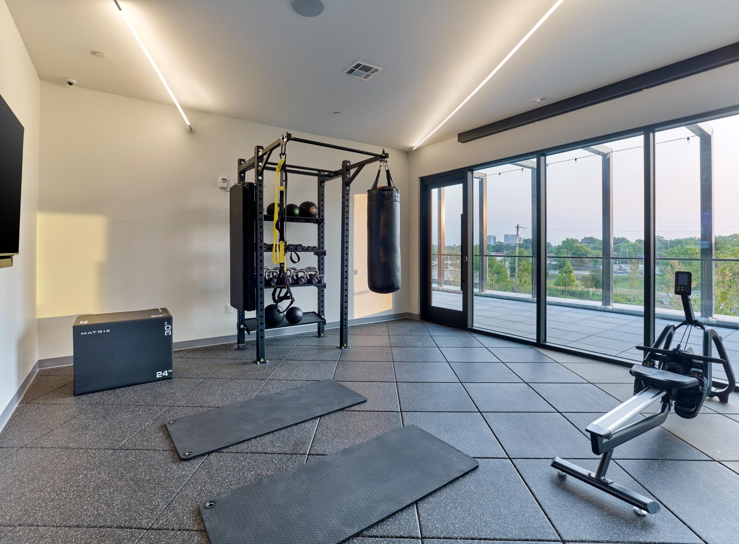 A home gym with a punching bag, weight rack, and exercise equipment.