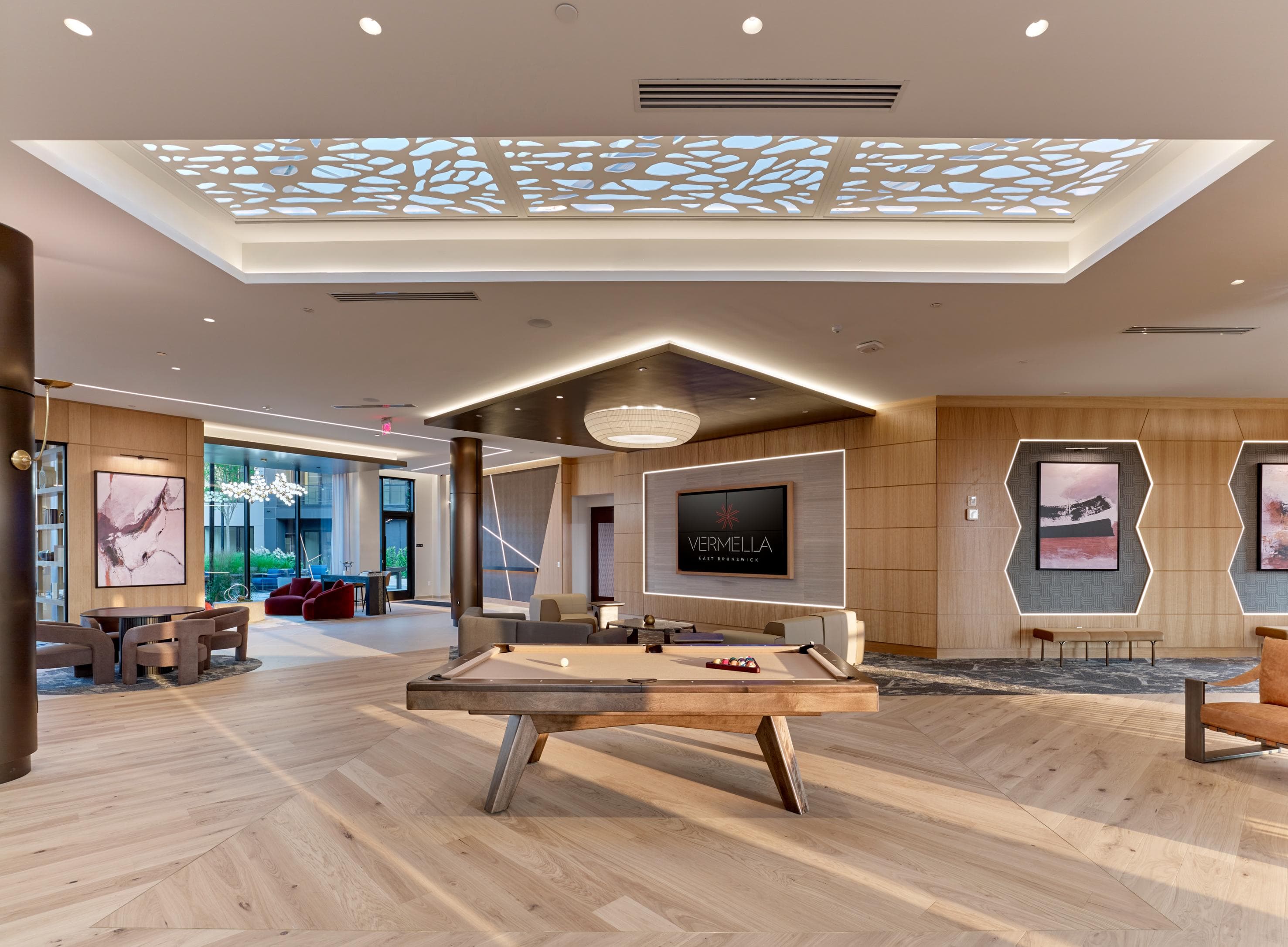 A room with a pool table and a TV mounted on the wall.