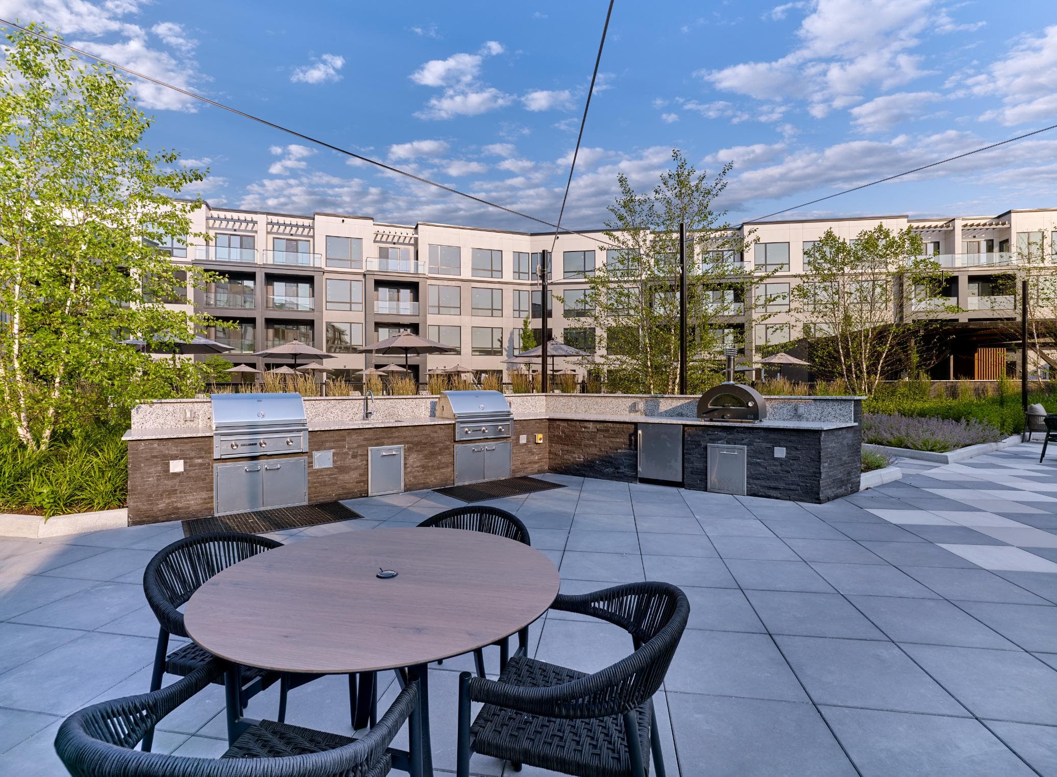 A patio with a table and chairs is in front of a building.