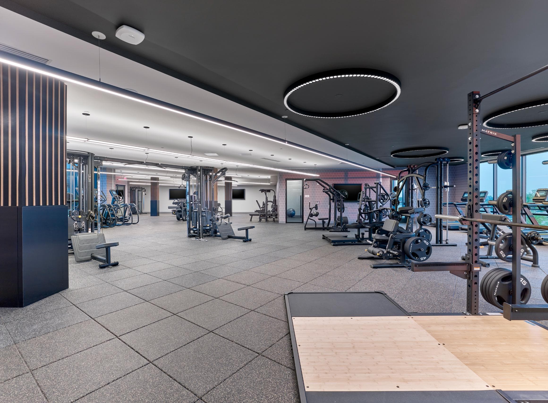 A gym with a variety of equipment including weights and cardio machines.