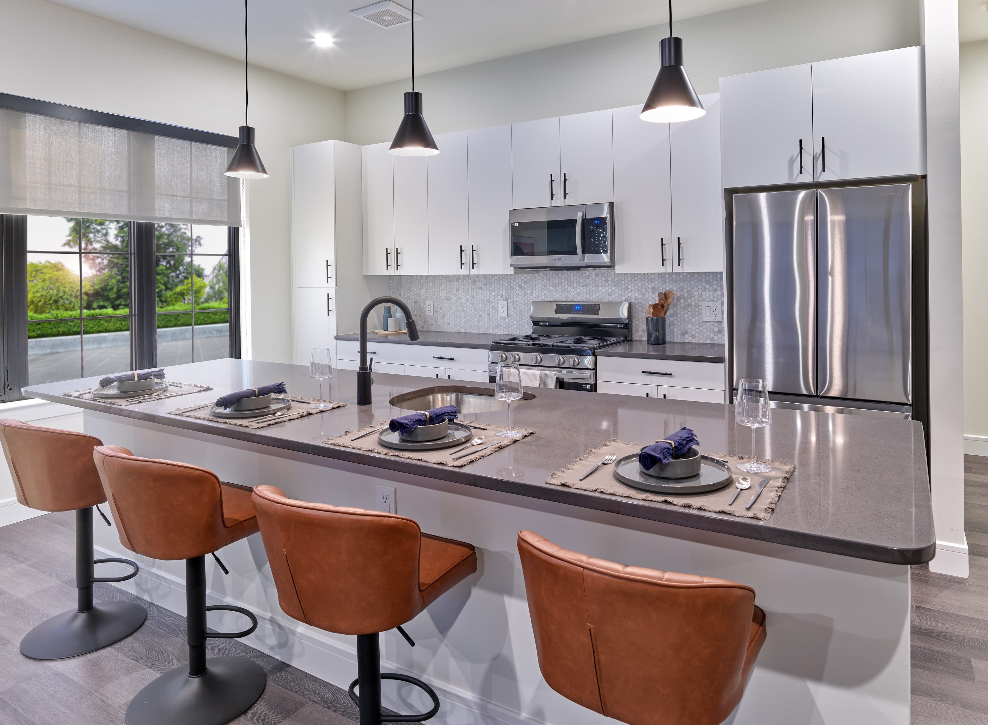 A modern kitchen with a bar area and chairs.