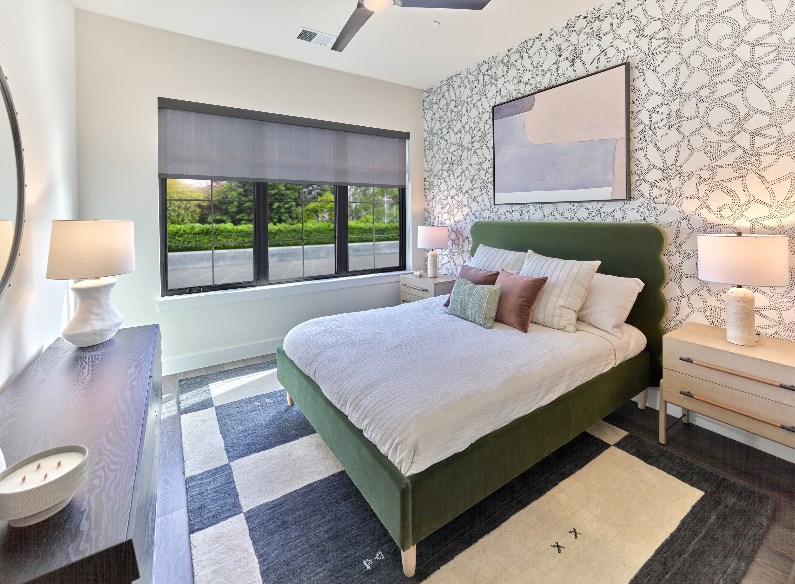 A bedroom with a green bed and a white ceiling fan.