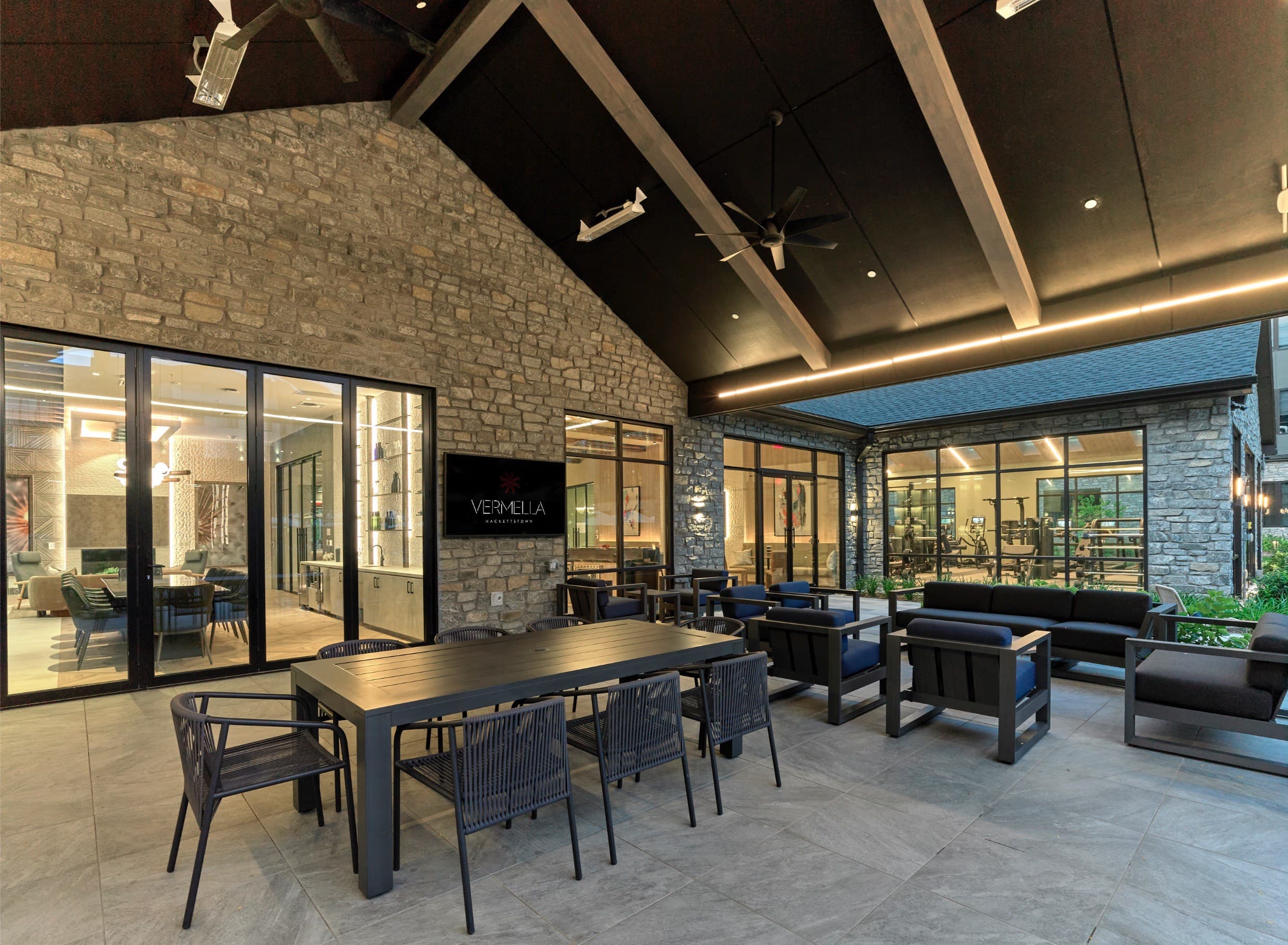 A modern dining area with a stone wall and glass doors.