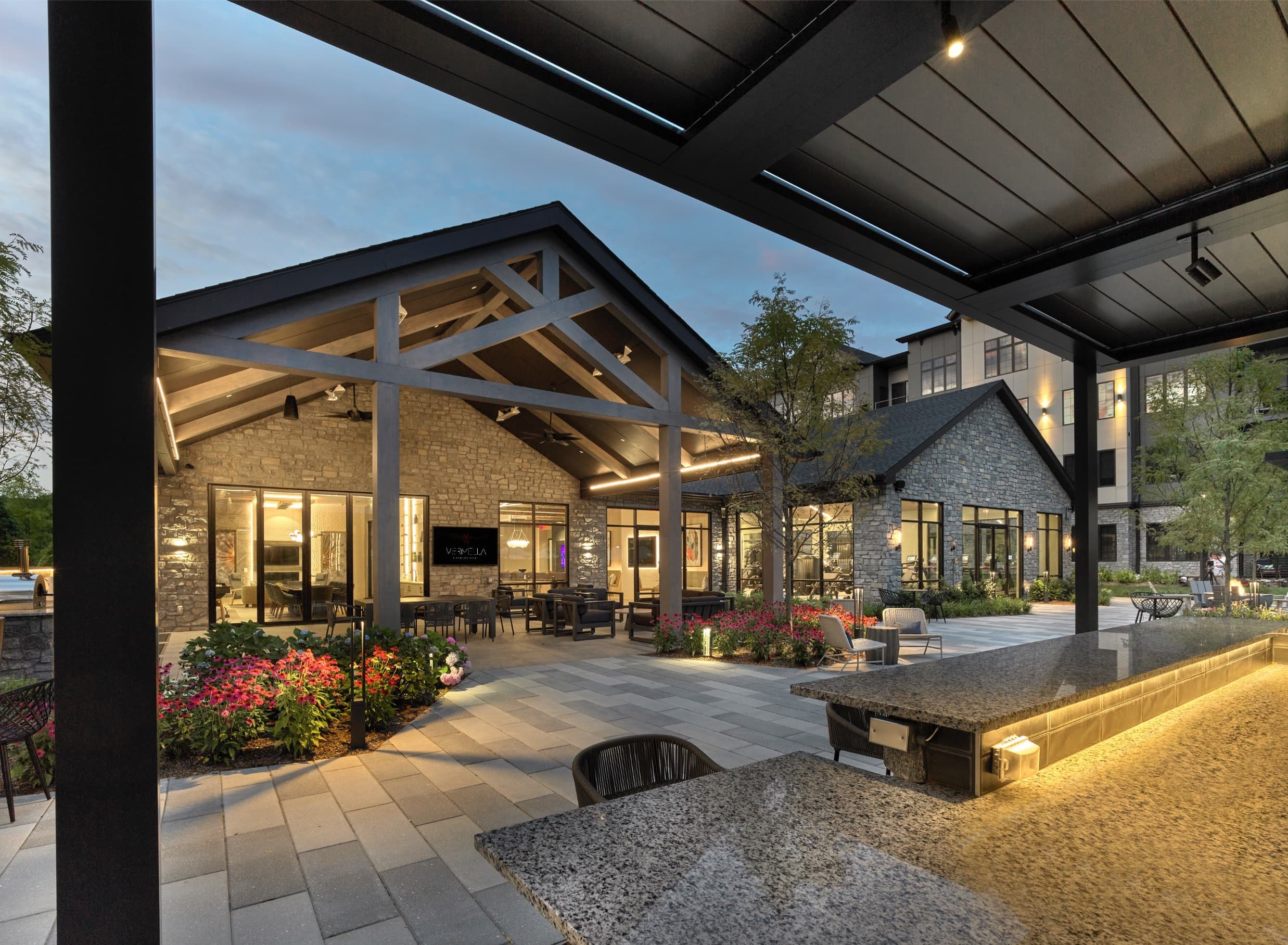 A modern building with a stone facade and a covered outdoor seating area.