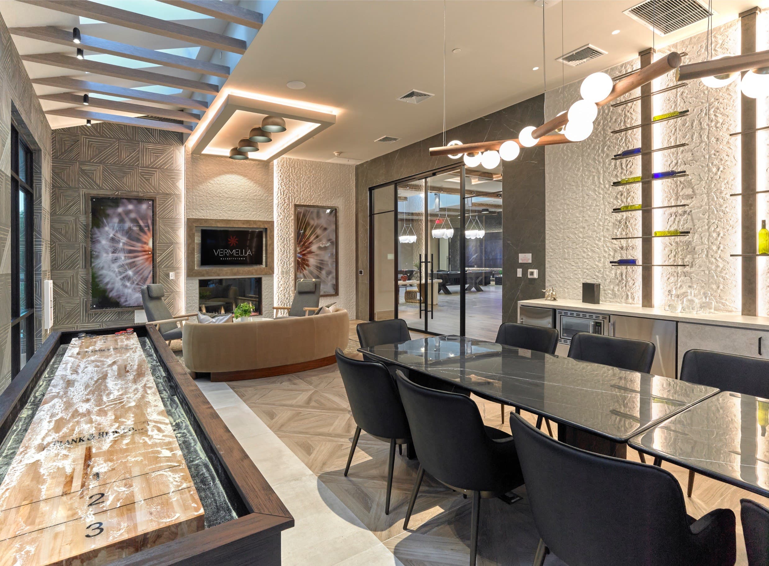 A billiard table is in the middle of a room with a glass wall and a row of chairs.