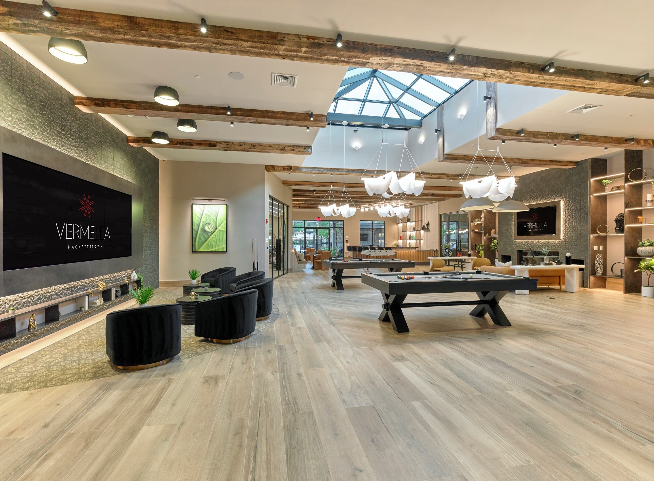 A spacious room with a pool table and a skylight.