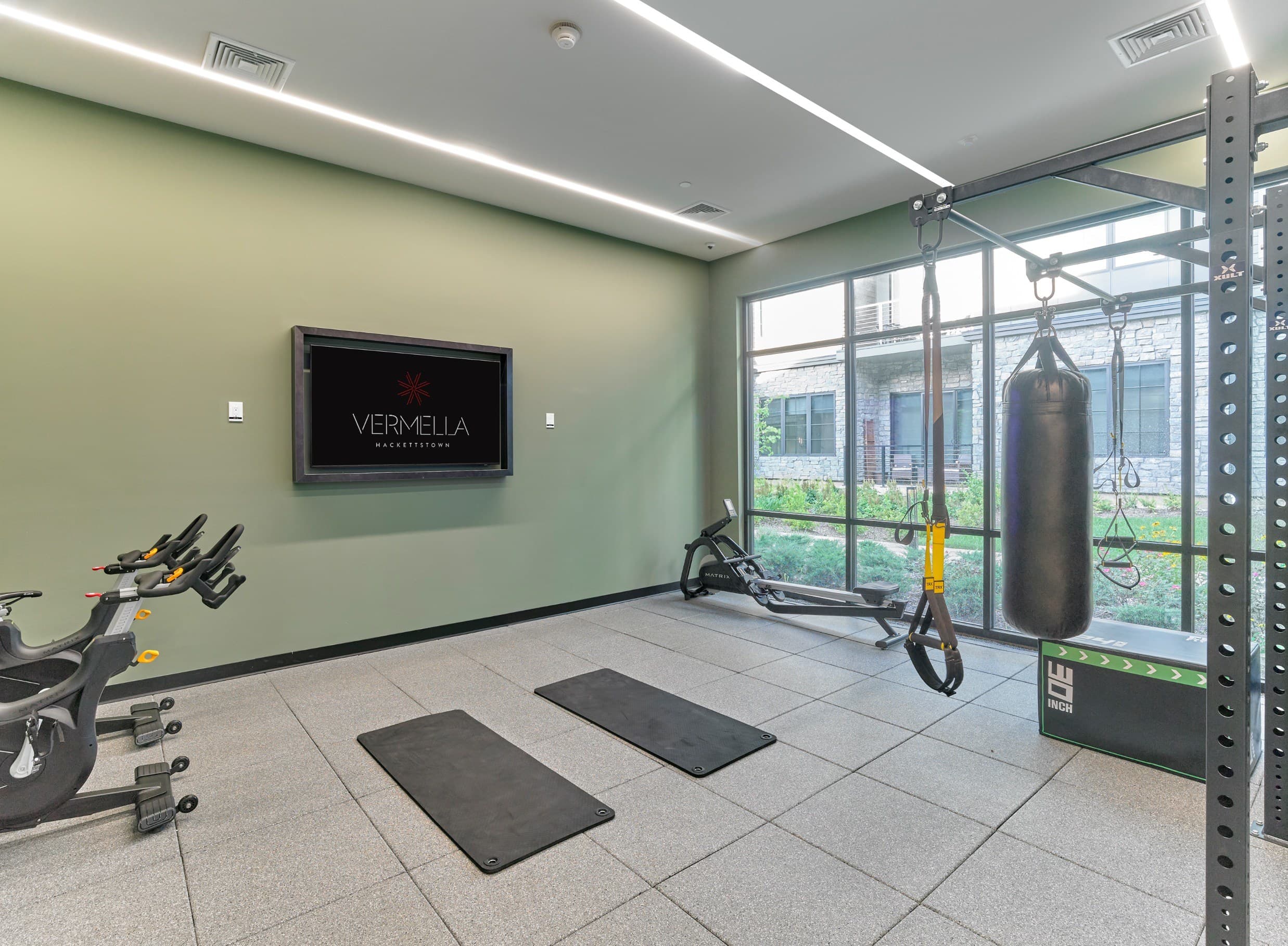 A gym with a green wall and a TV displaying the word