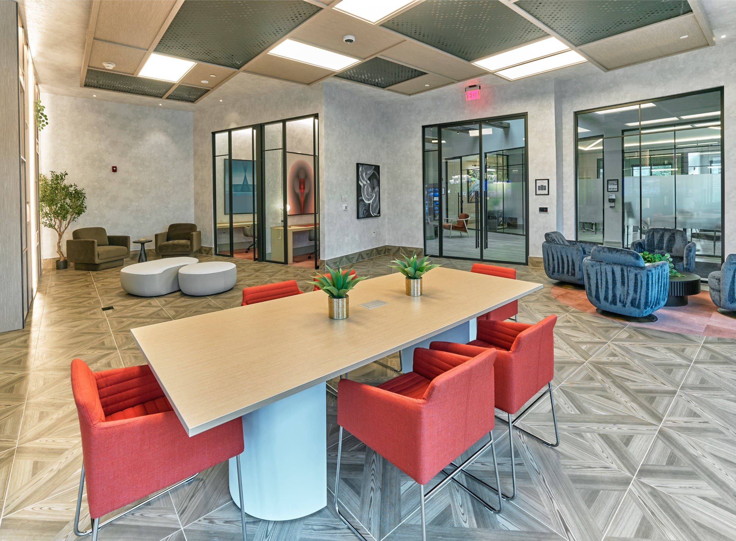 A conference room with a long table and red chairs.