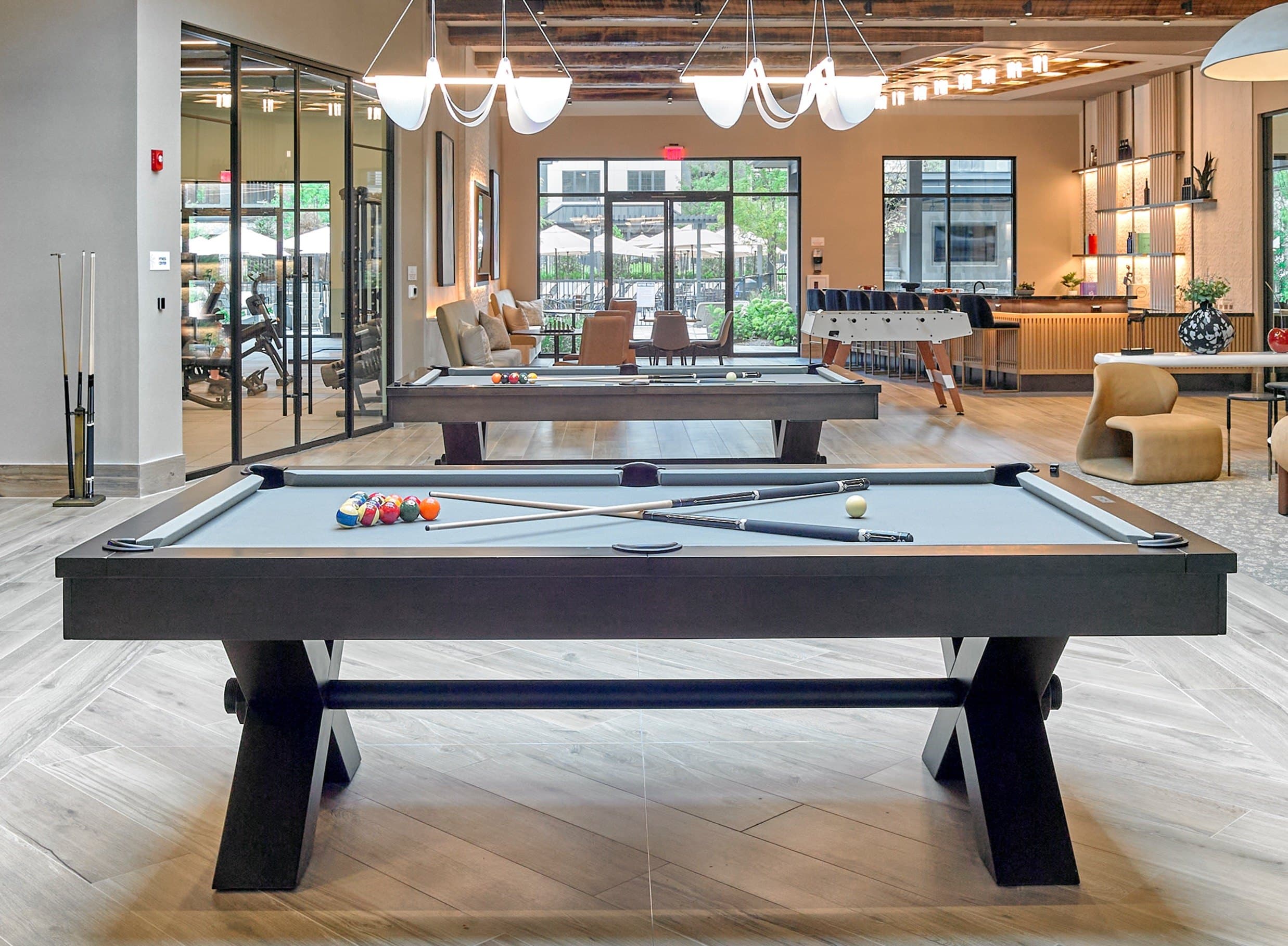 A pool table in a room with a view of the outside.