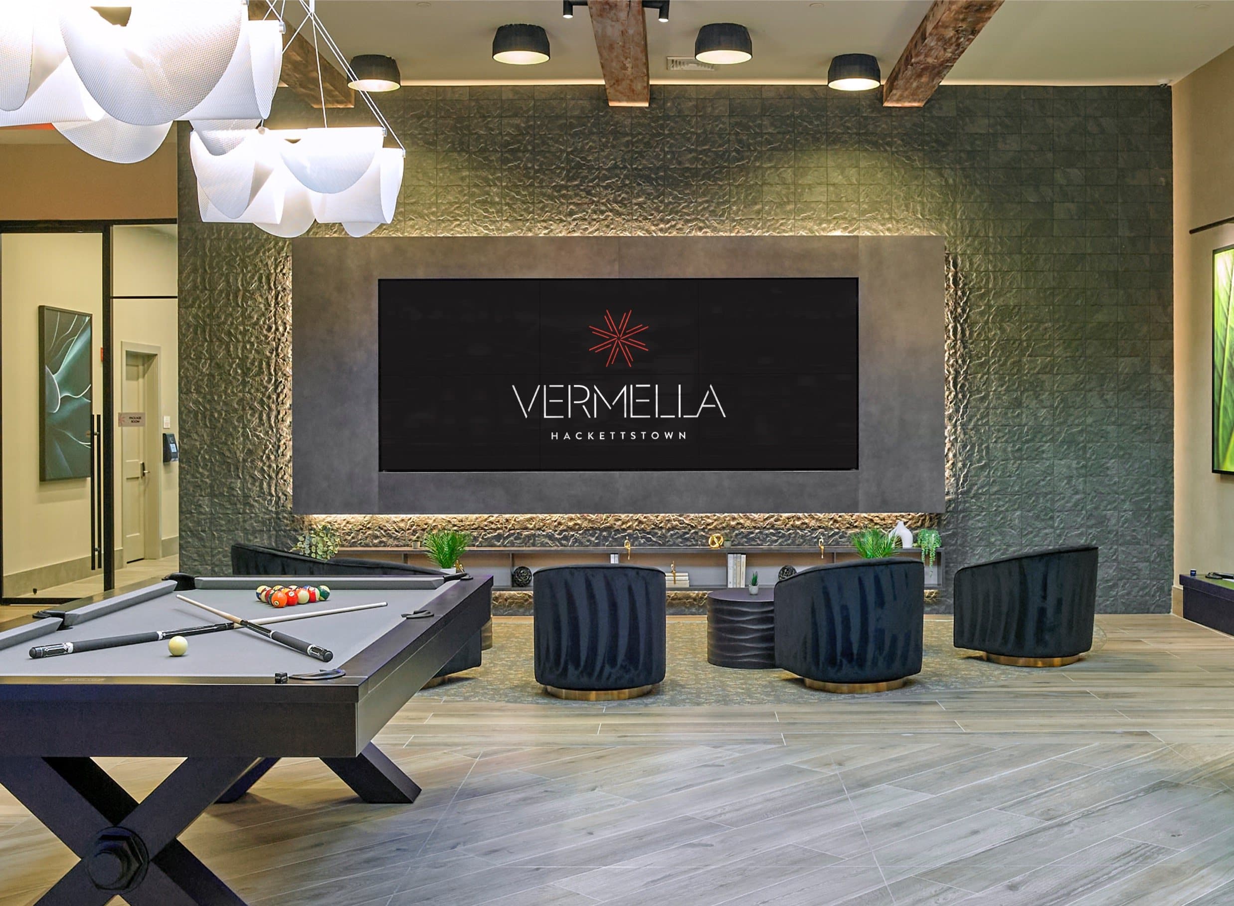 A pool table is in the middle of a room with a sign that says Vermella.