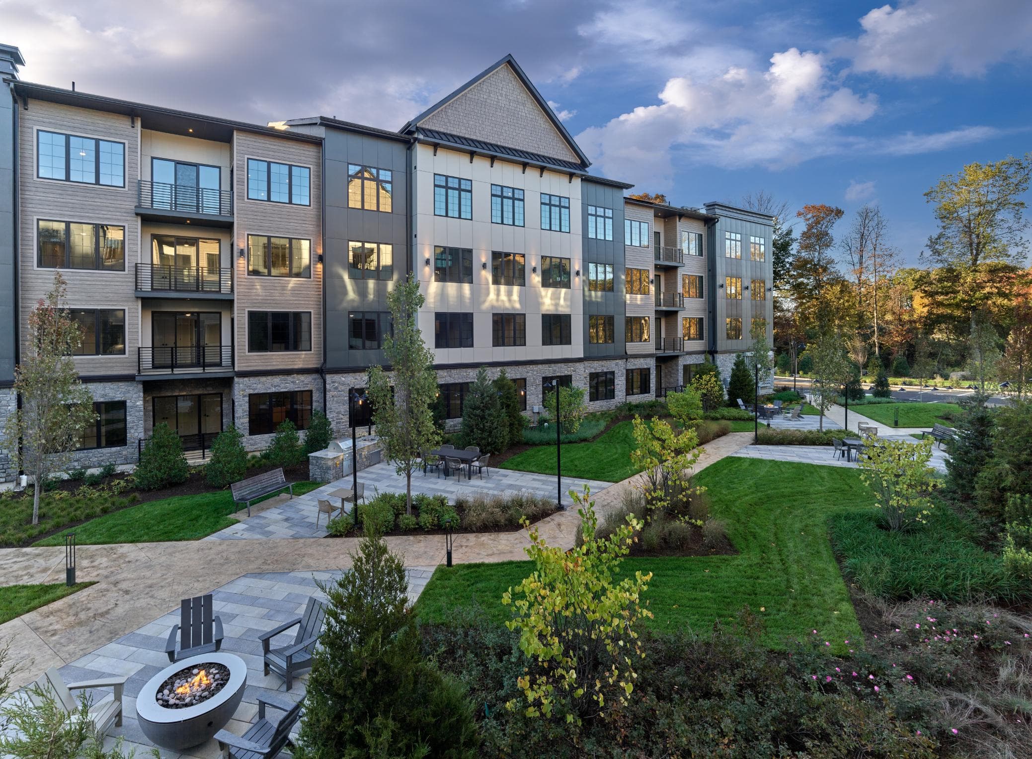 A modern apartment complex with a fire pit in the courtyard.