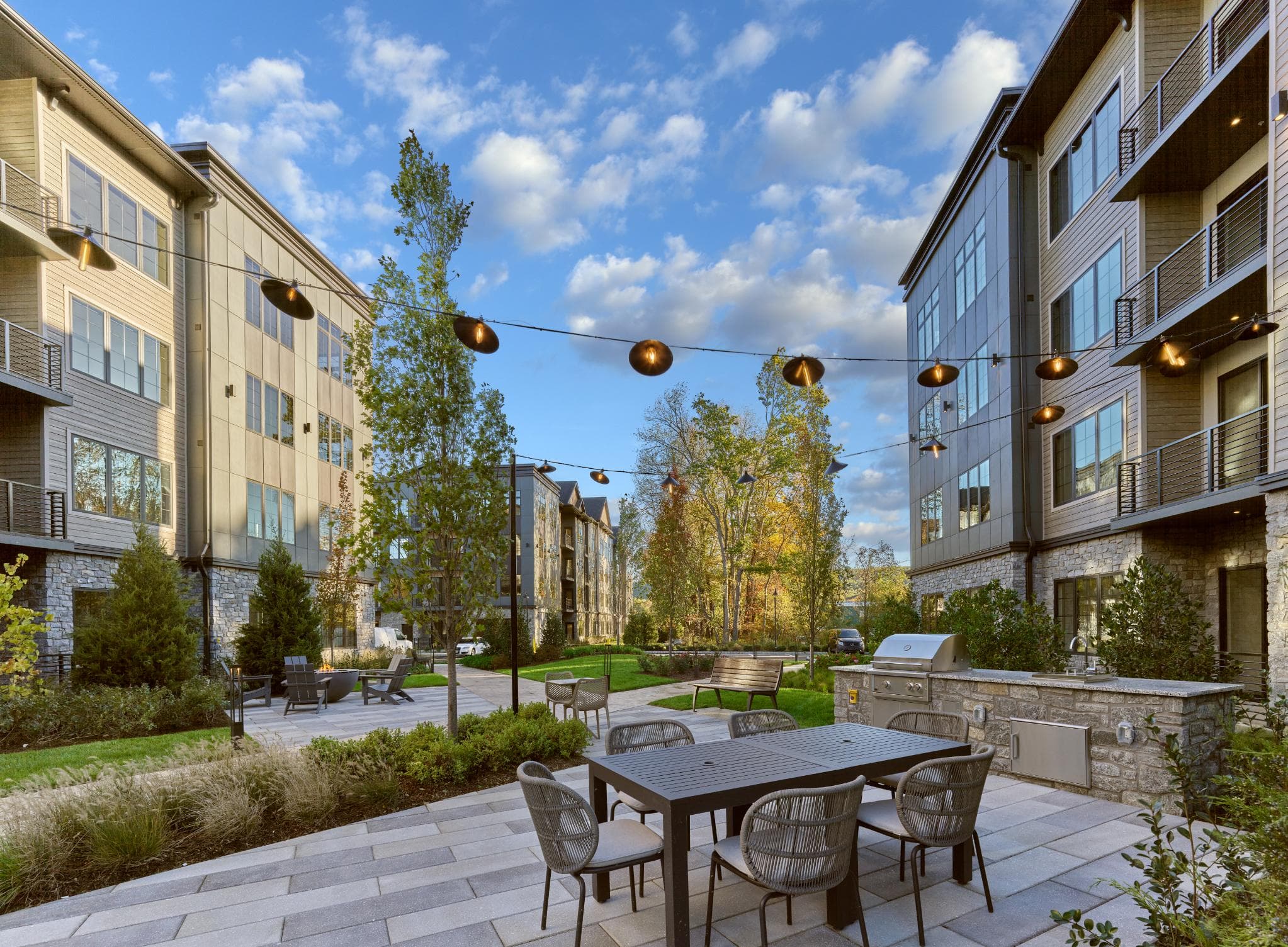 A patio with a table and chairs is surrounded by apartment buildings.