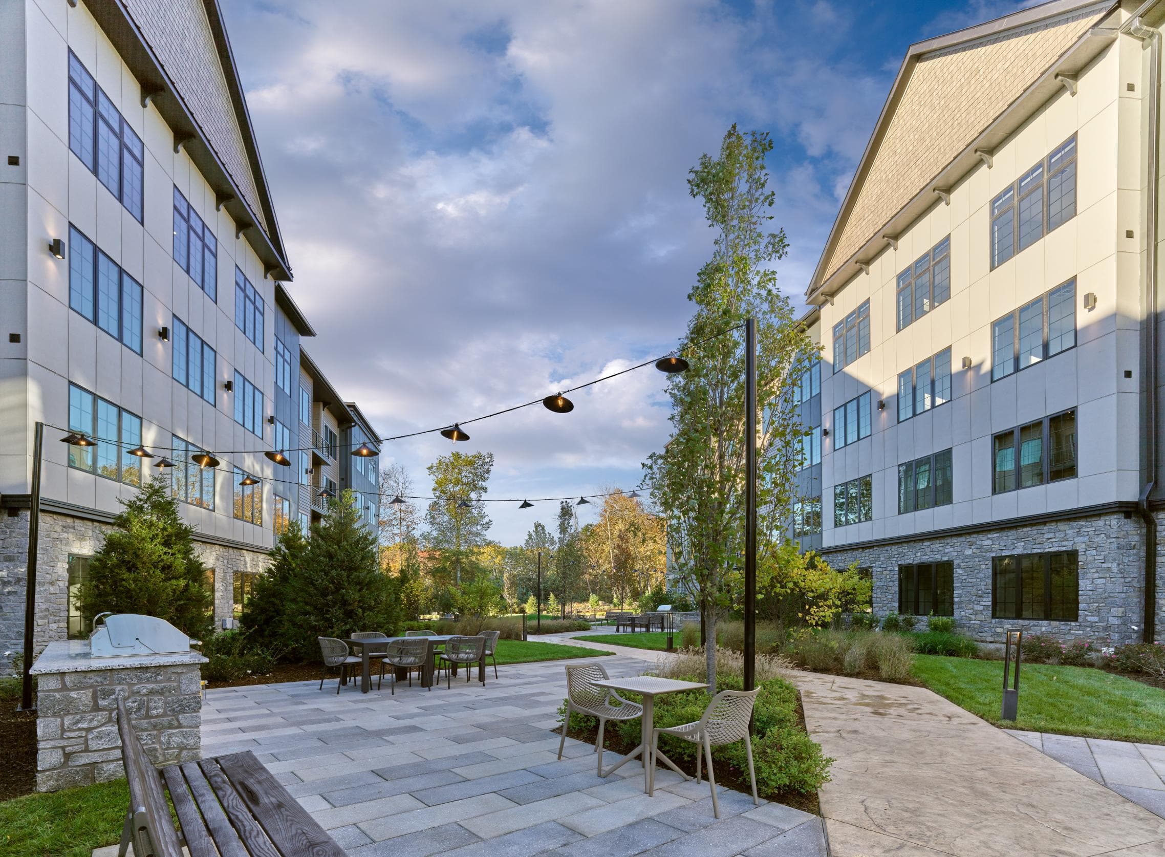 A courtyard with tables and chairs surrounded by buildings.